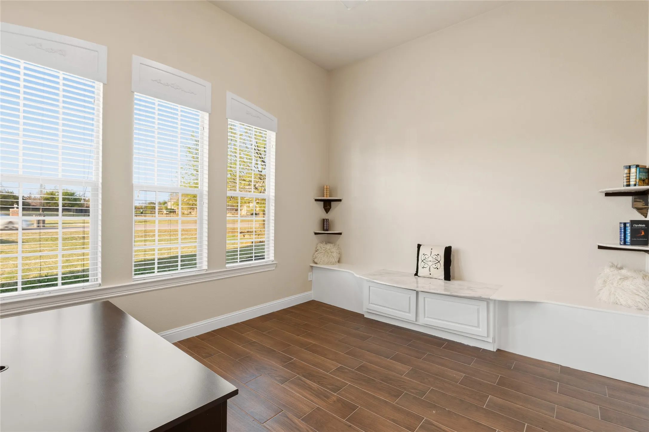 Unfurnished office featuring wood tiled floors and baseboards