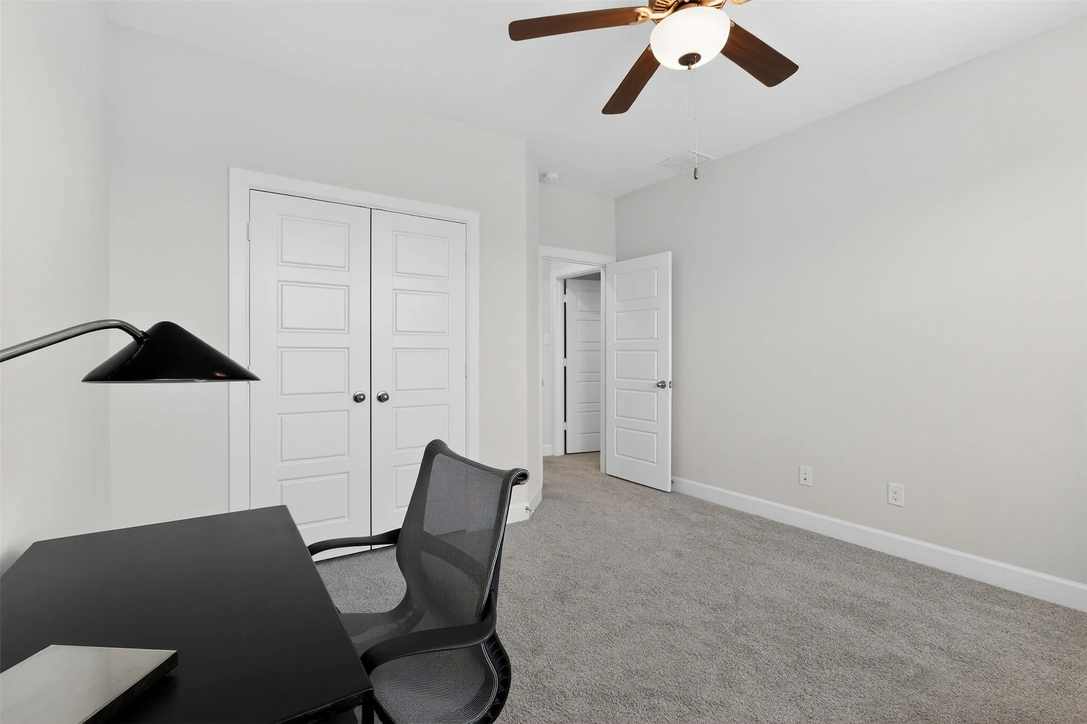 Unfurnished bedroom featuring light colored carpet, ceiling fan, and a closet