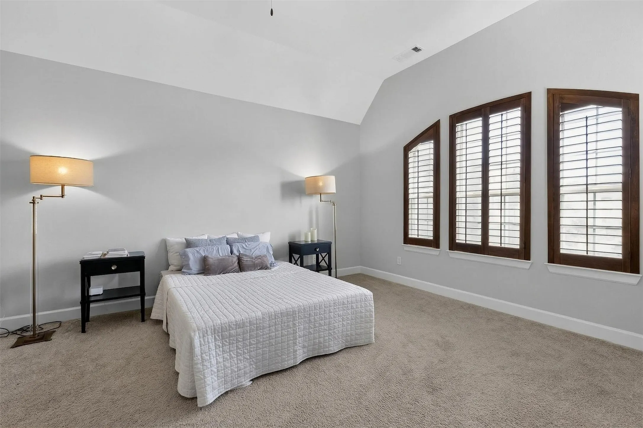 Bedroom with lofted ceiling, a ceiling fan, and light colored carpet