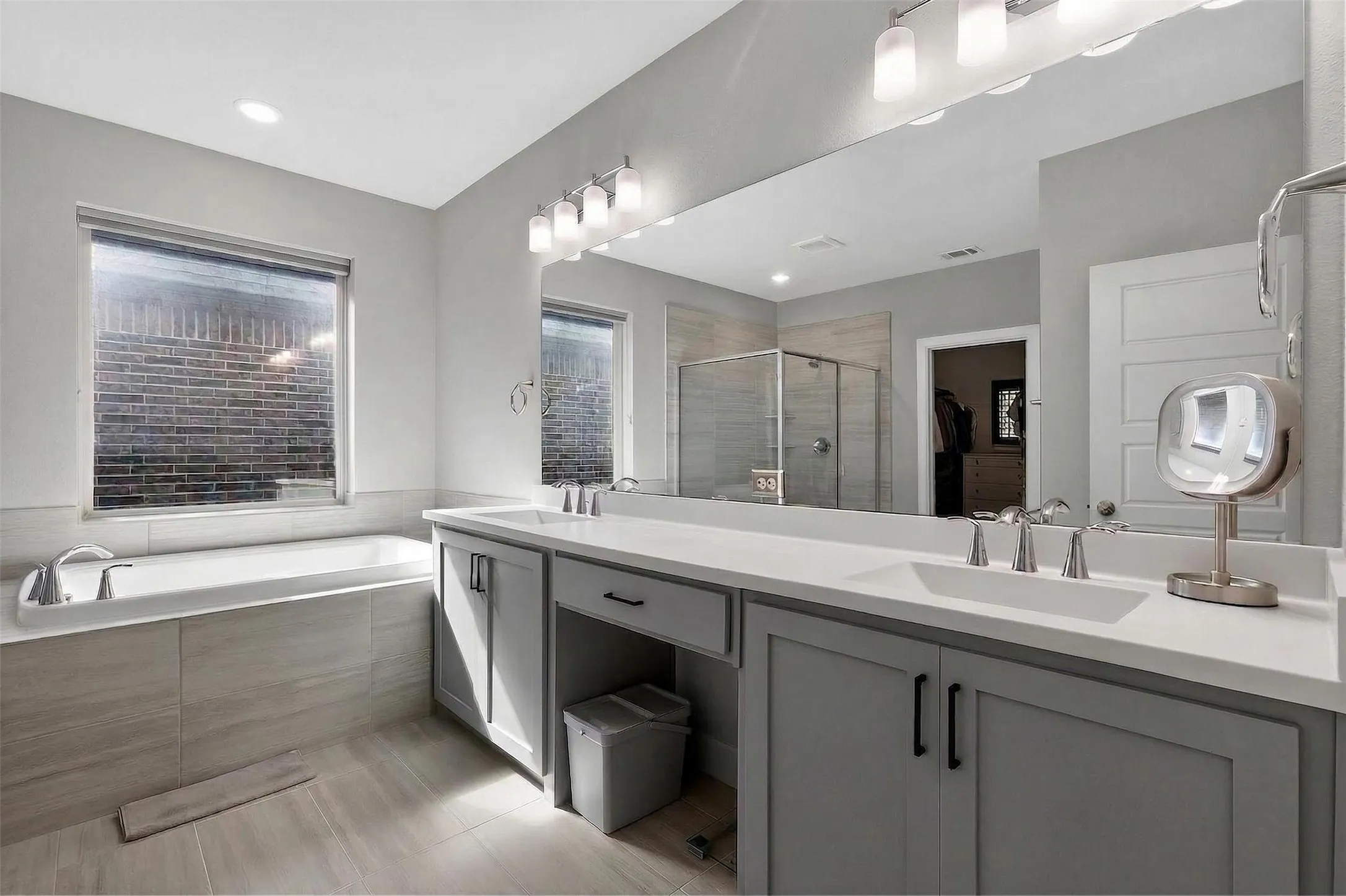 Bathroom with a spacious closet, a stall shower, a garden tub, and light tile patterned floors