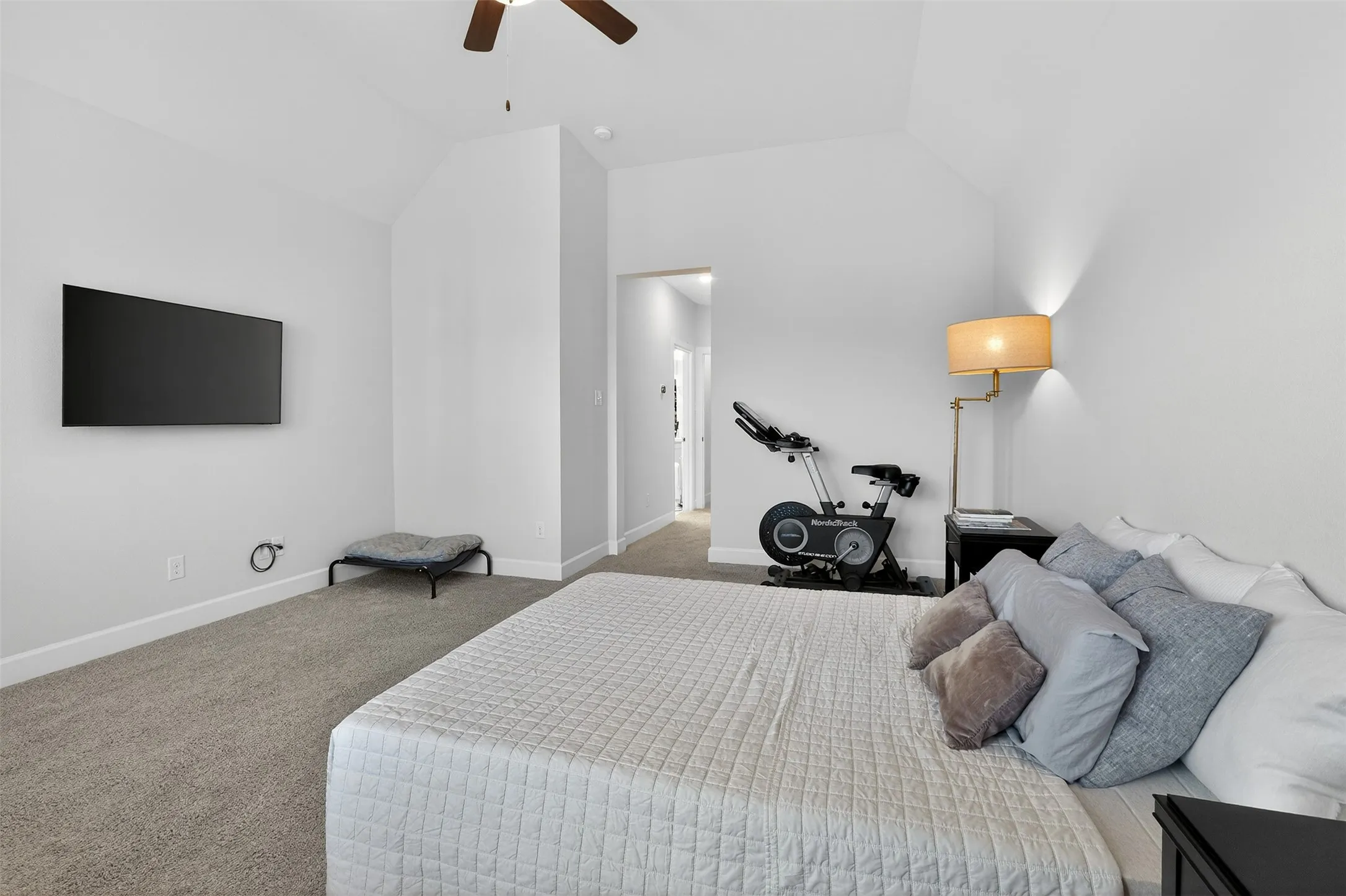 Bedroom with light carpet and vaulted ceiling