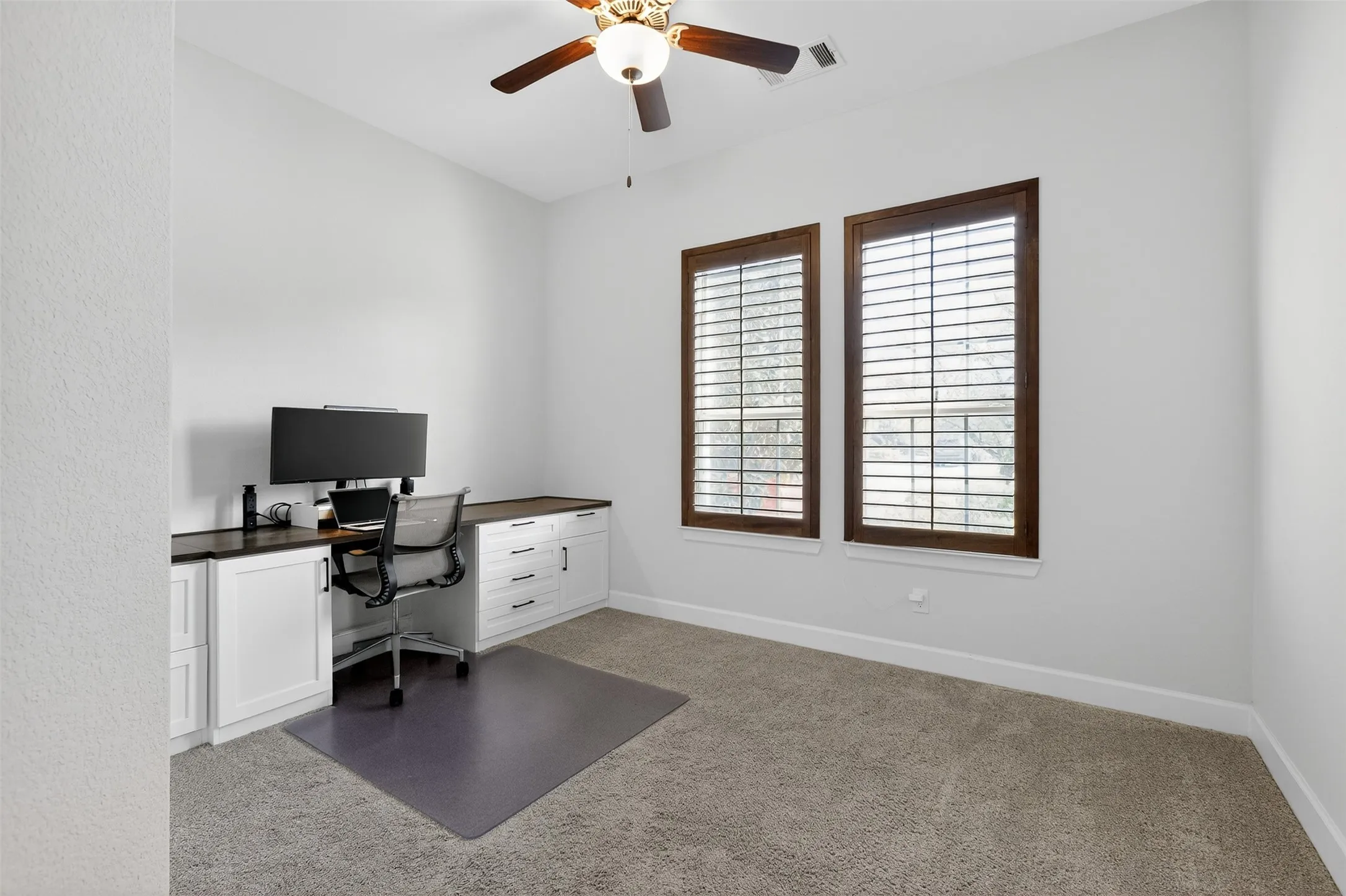 Office featuring dark colored carpet and a ceiling fan