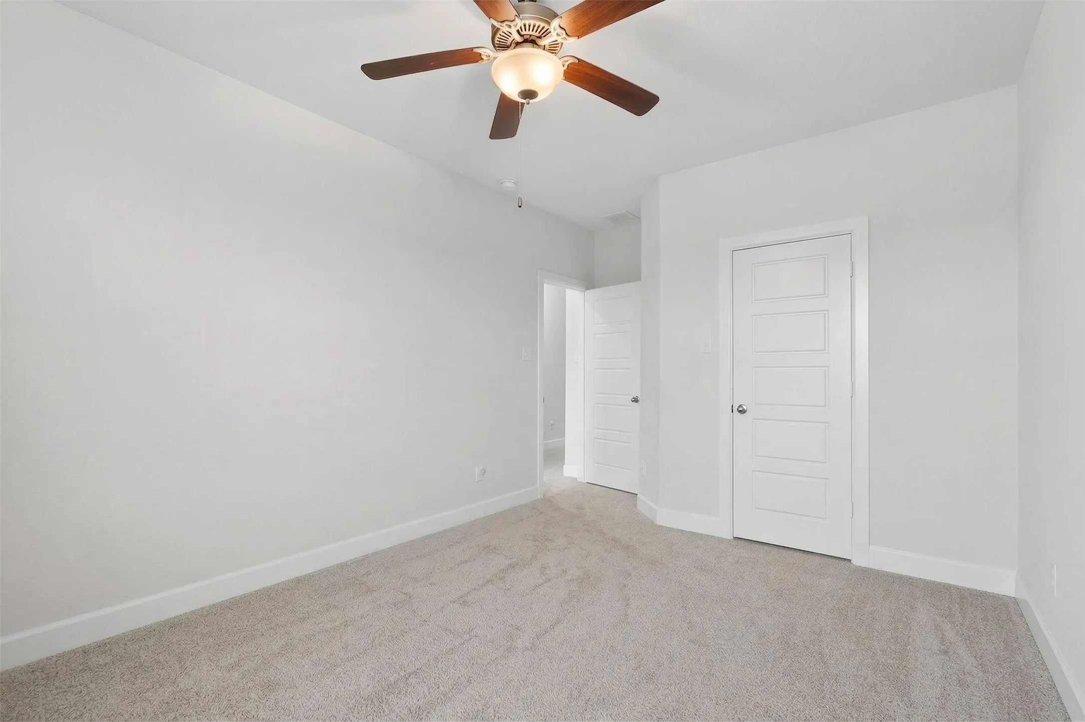 Spare room featuring carpet and a ceiling fan
