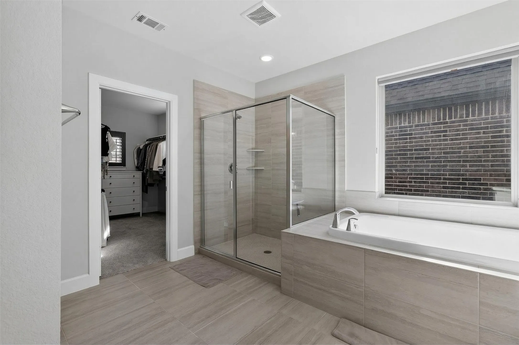 Bathroom with a garden tub, vanity, and a shower stall
