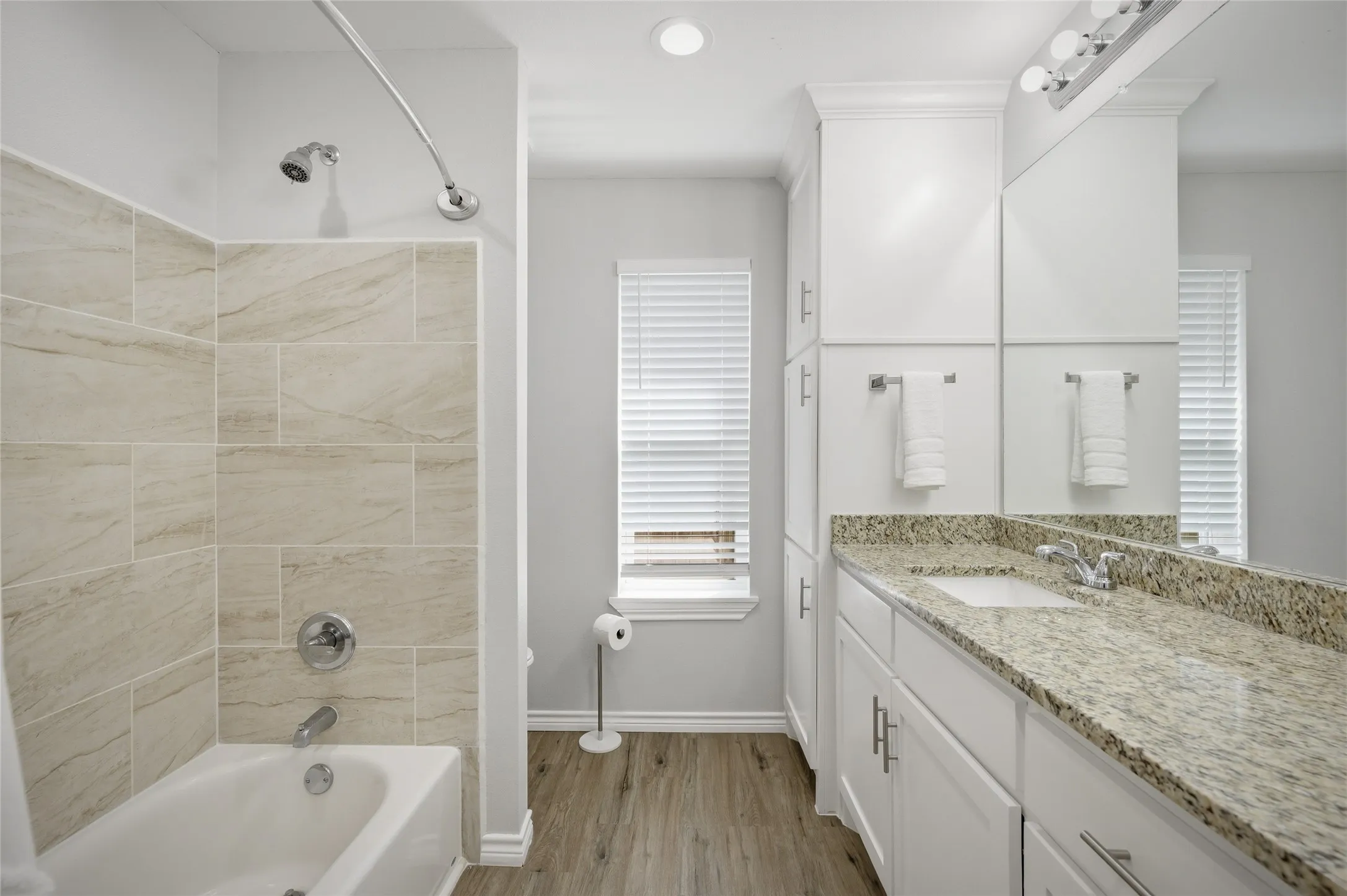 Oversized bathtub with shower in the primary bathroom and a large linen closet.