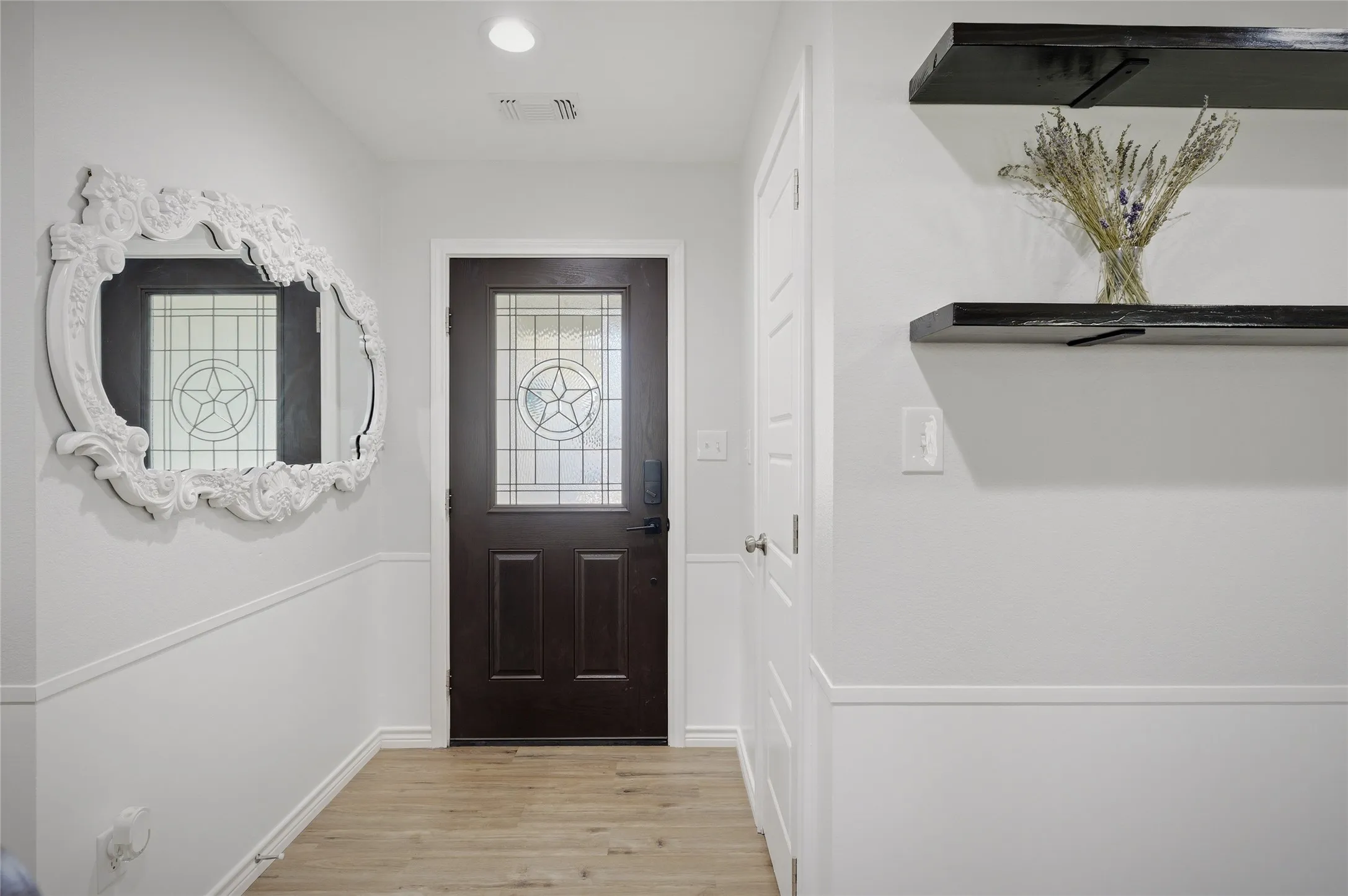 Custom Texas Star front door and large decorative mirror compliment the home's entryway.