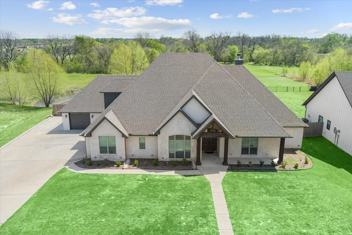 French country style house with a front lawn, stucco siding, a shingled roof, concrete driveway, and a garage