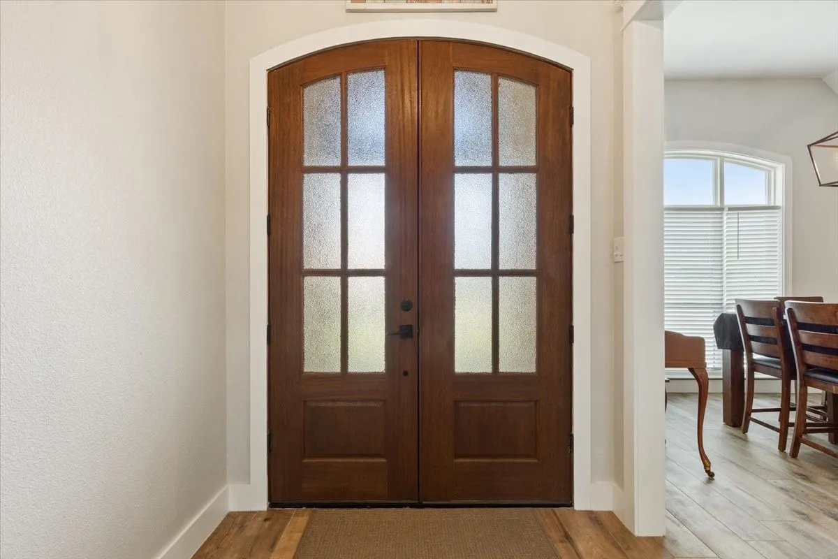 Entryway featuring french doors, light wood-type flooring, and arched walkways