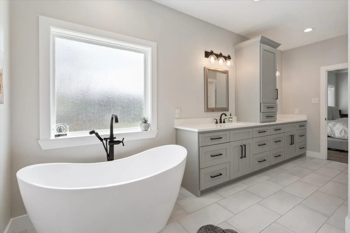 Full bath with ensuite bath, vanity, a soaking tub, and healthy amount of natural light