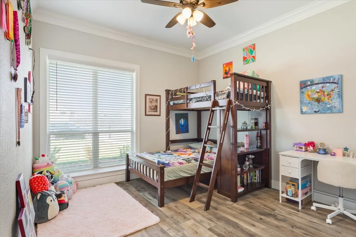 Bedroom featuring ornamental molding, light wood finished floors, and ceiling fan