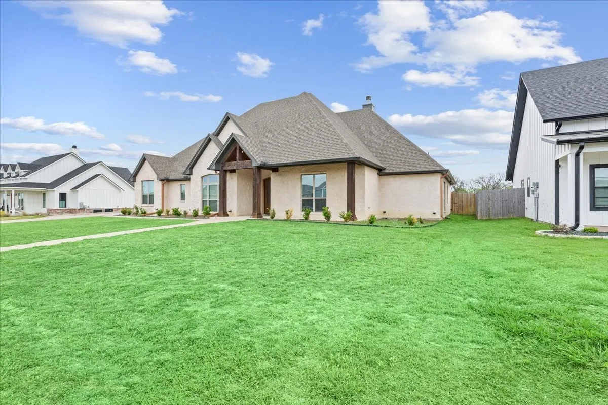 View of front of property featuring a shingled roof and a chimney