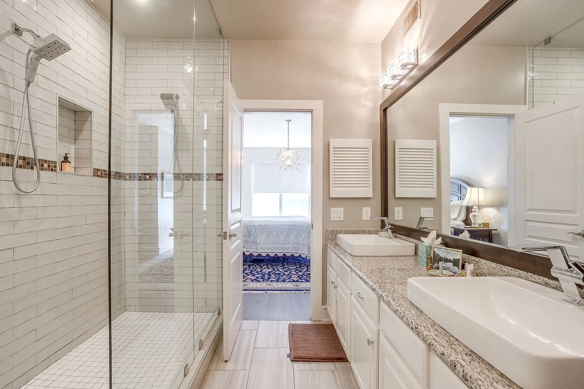 Ensuite bathroom with a shower stall, hanging lights, and double vanity