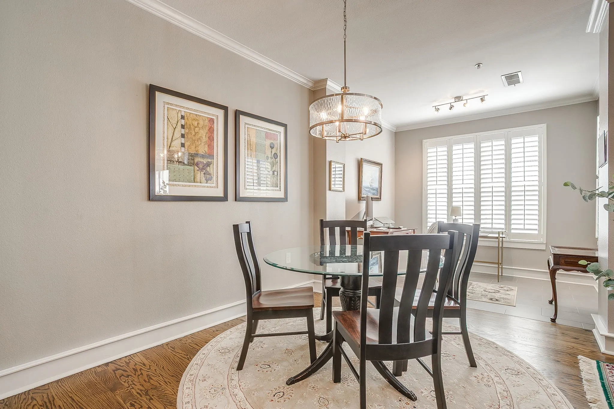 Dining space with crown molding, light wood-style floors, and a chandelier