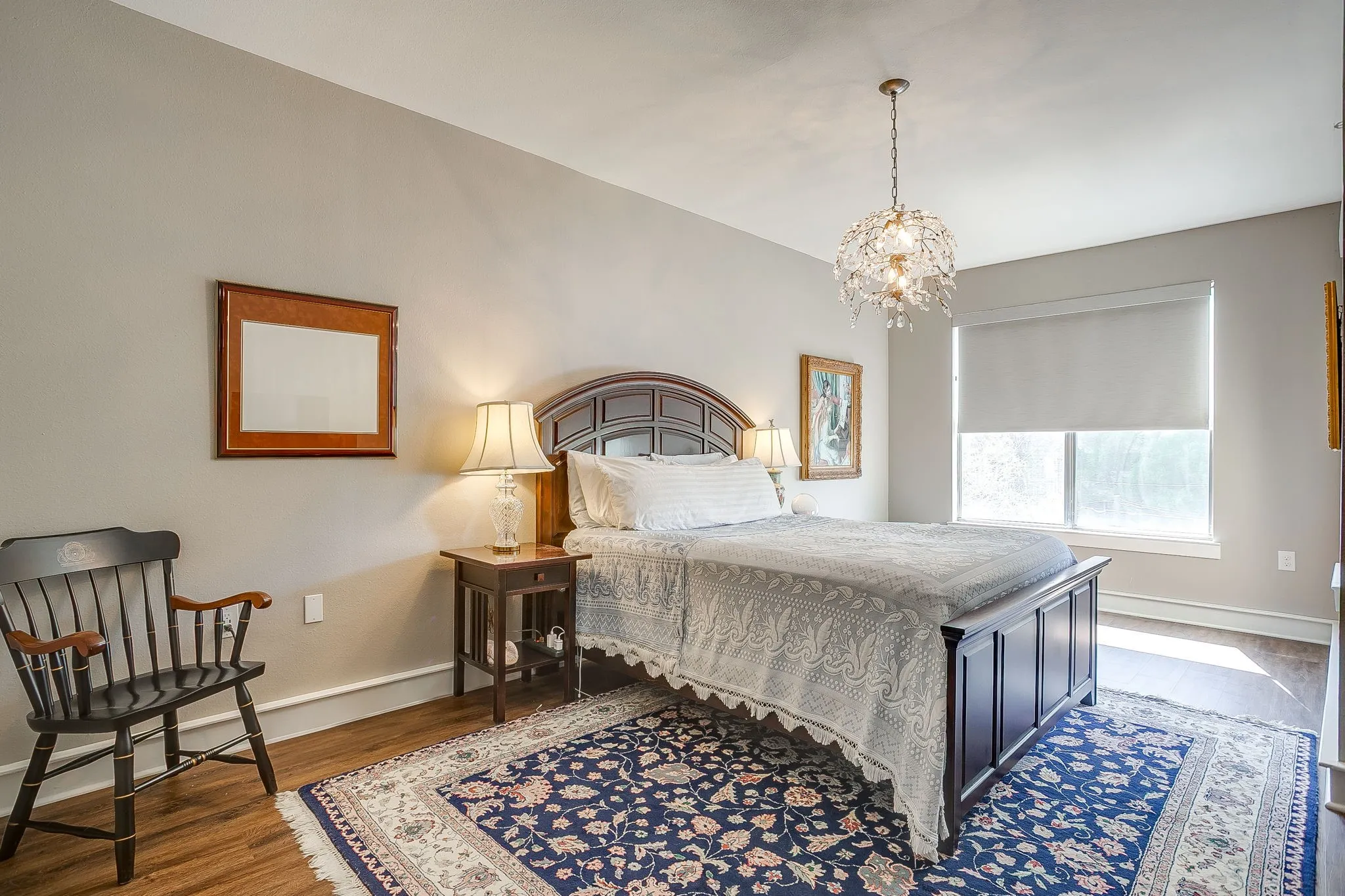 Bedroom with dark wood finished floors and hanging lights