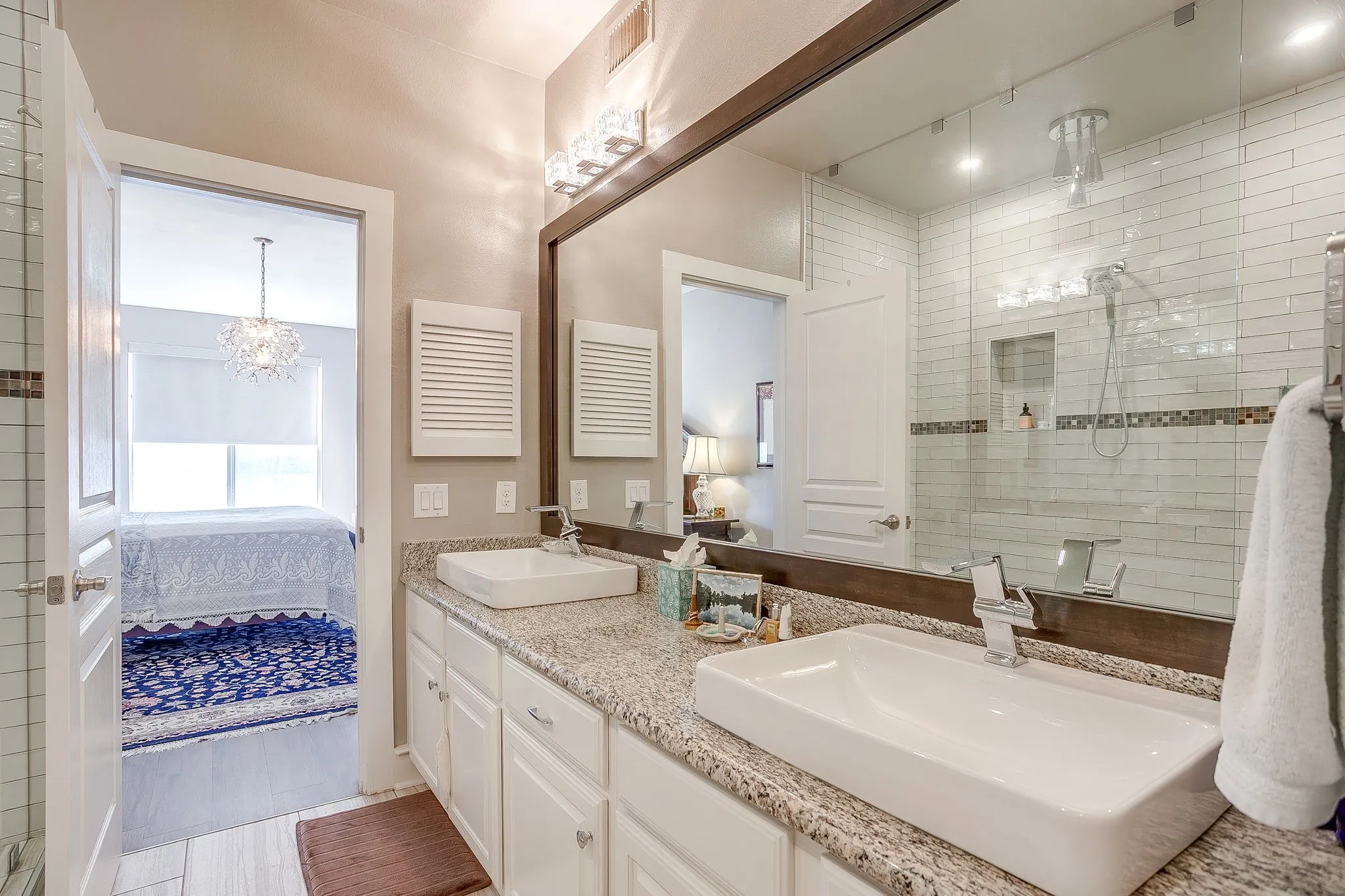 Ensuite bathroom with a stall shower, double vanity, and hanging lights