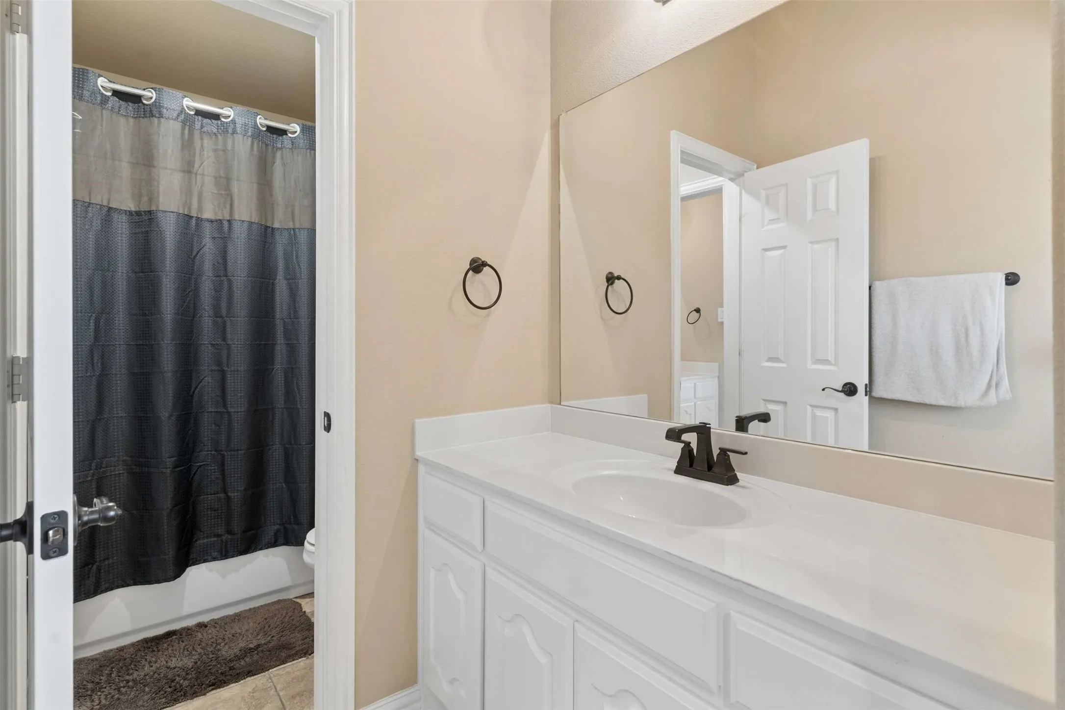Bathroom with vanity, light tile patterned floors, and shower / tub combo with curtain