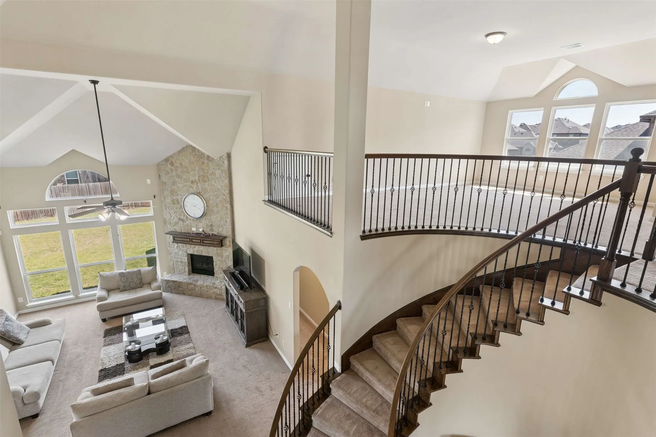 Living room featuring lofted ceiling, a fireplace, carpet, and ceiling fan