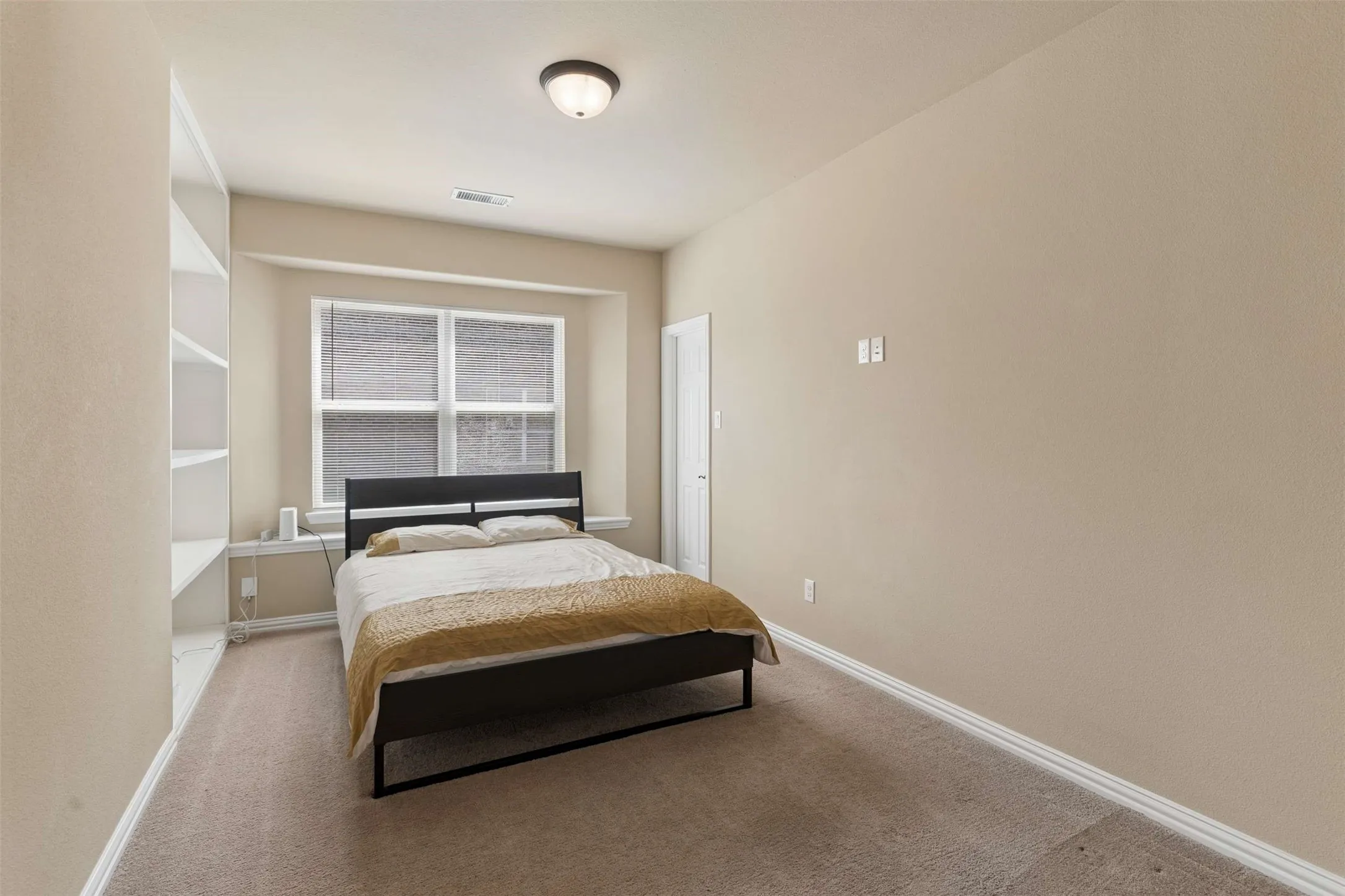 Bedroom featuring light colored carpet and baseboards