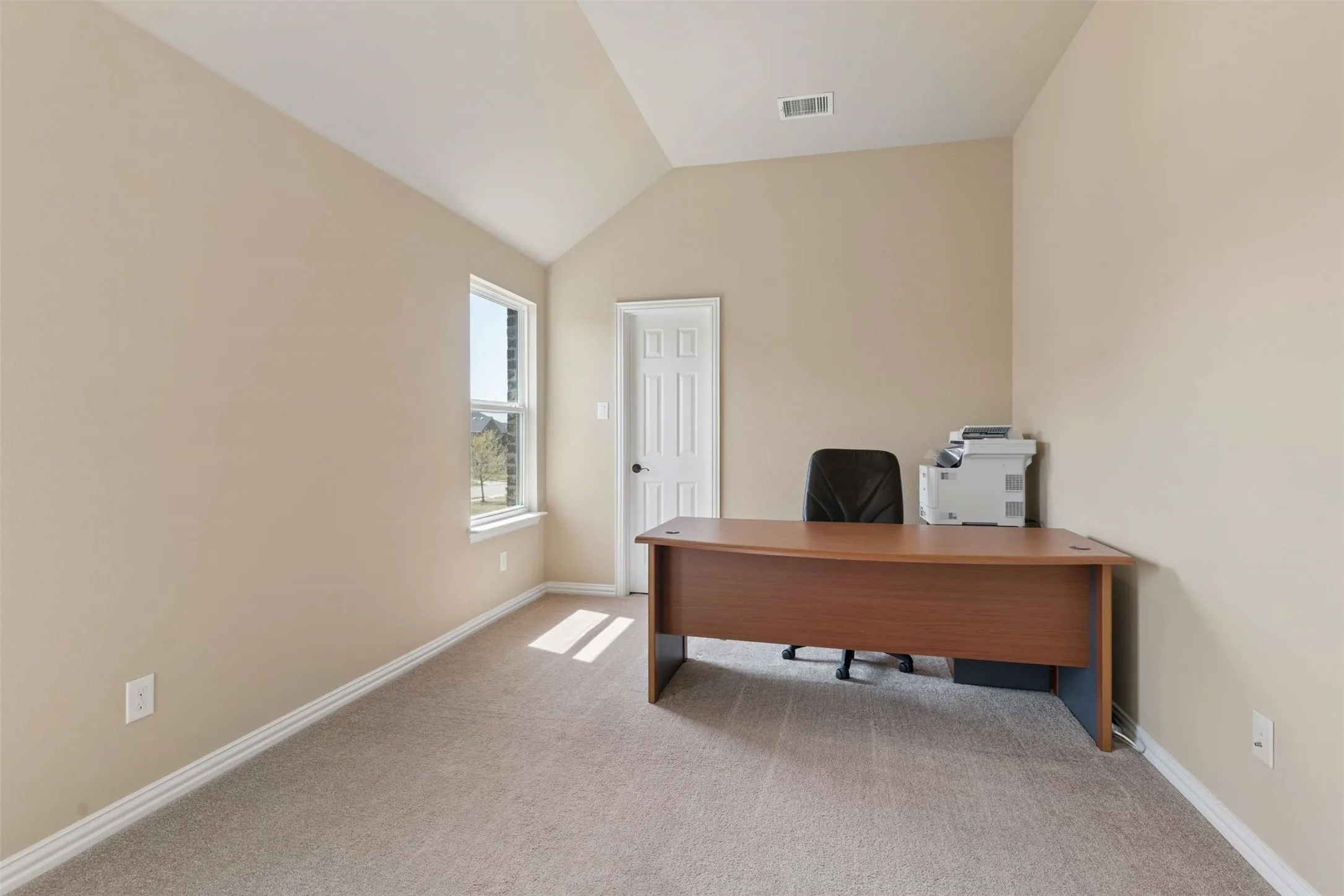 Office space featuring light carpet and lofted ceiling
