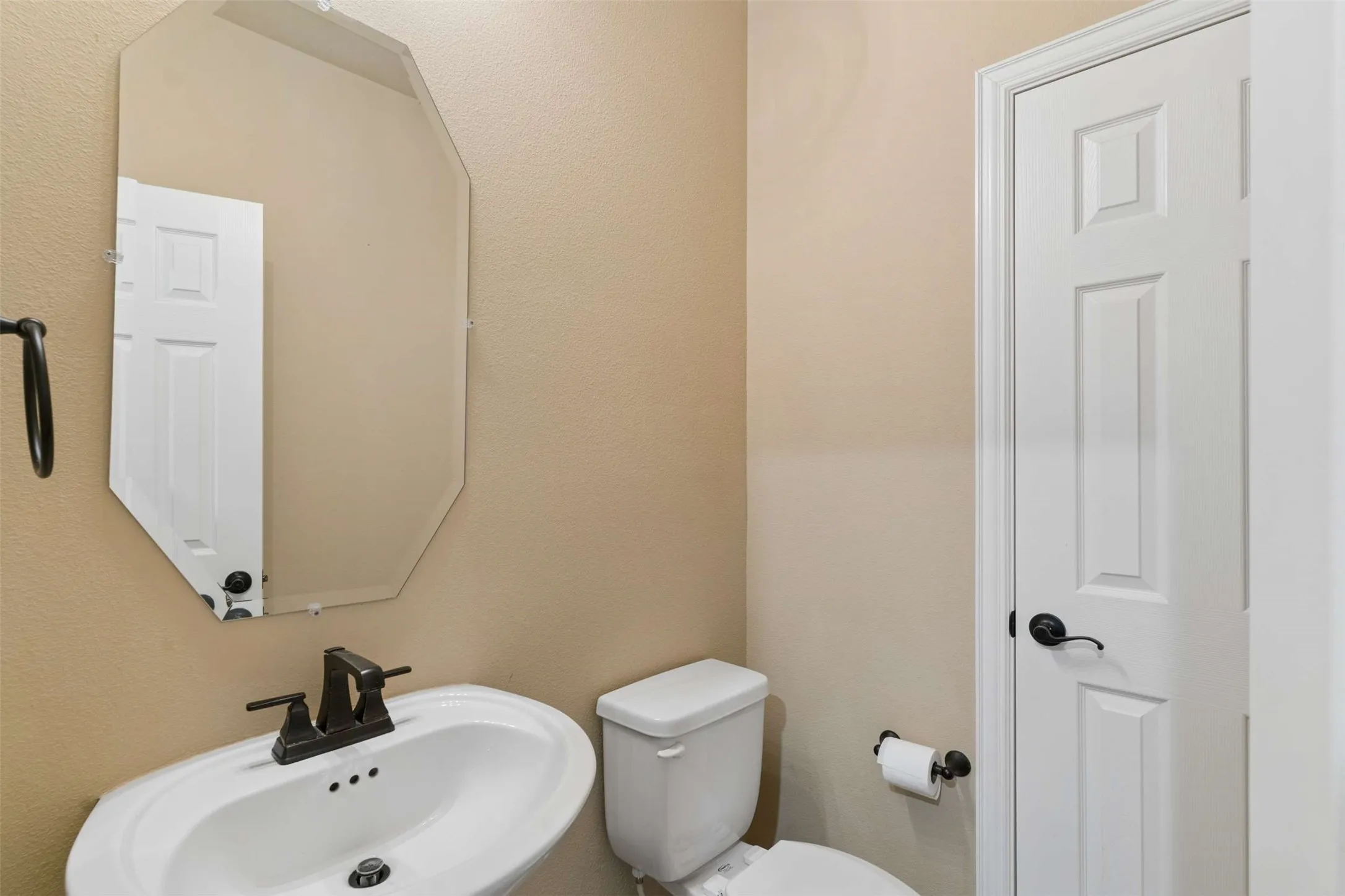 Half bathroom featuring a textured wall