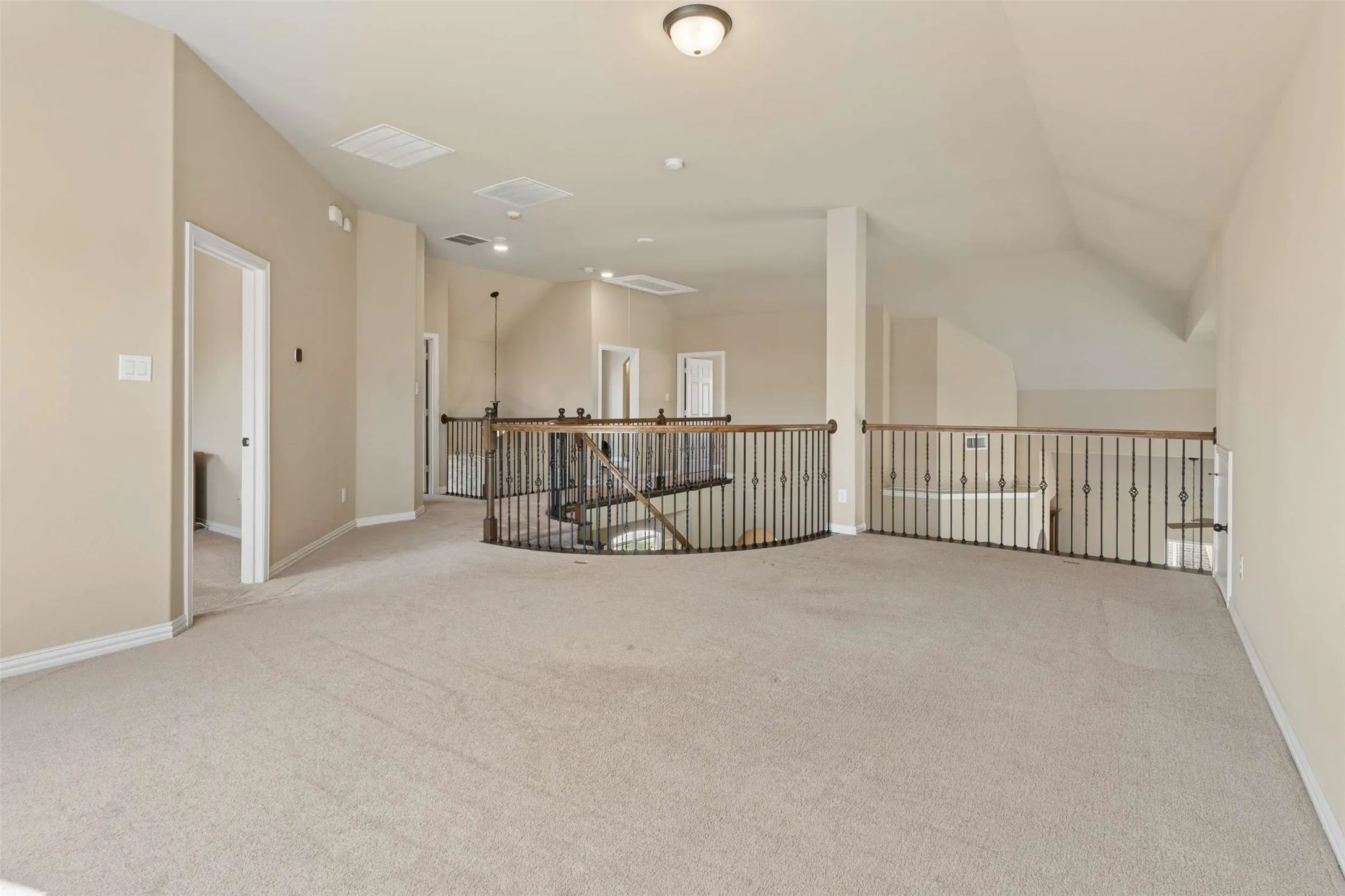 Unfurnished room with light colored carpet and vaulted ceiling