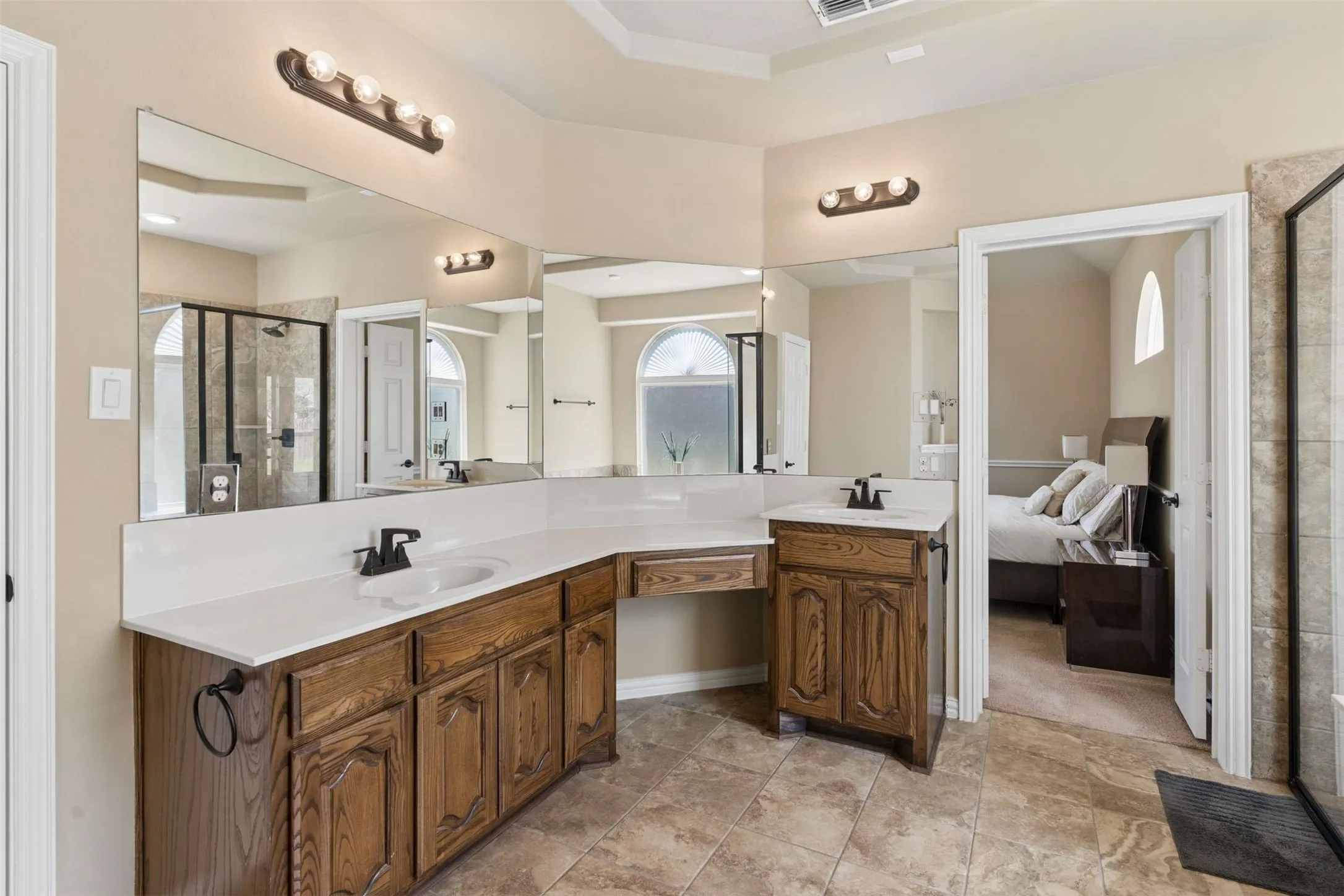 Bathroom featuring a shower stall, vanity, and ensuite bath