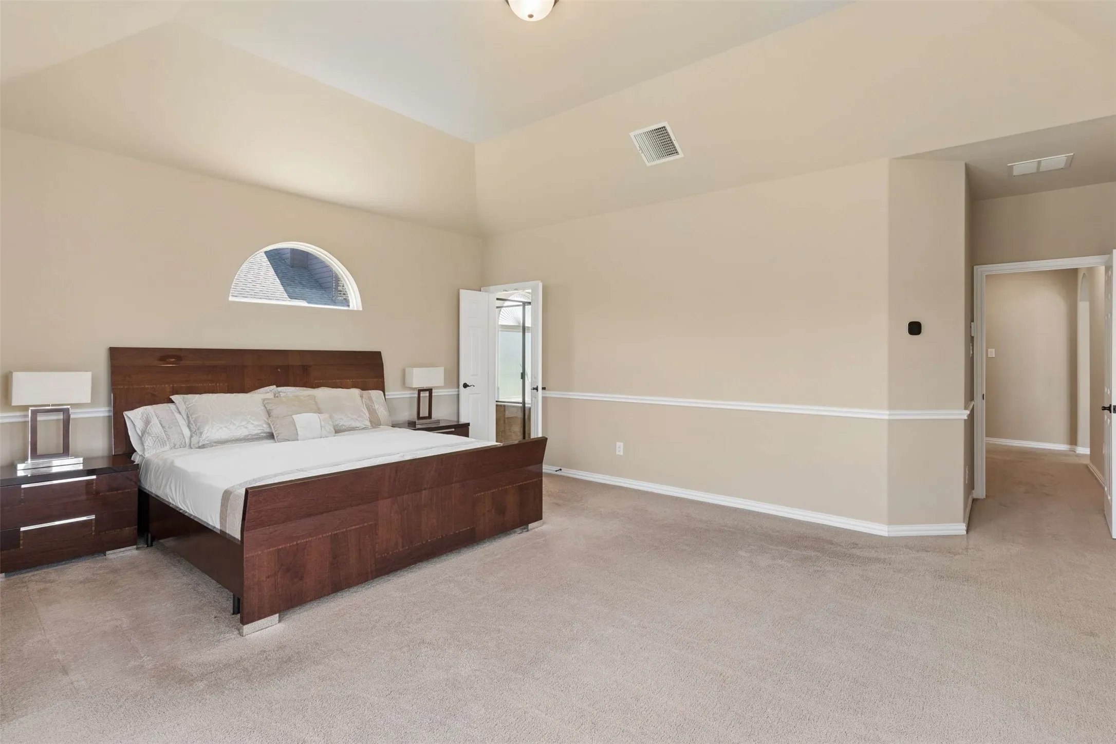 Bedroom featuring light carpet and vaulted ceiling