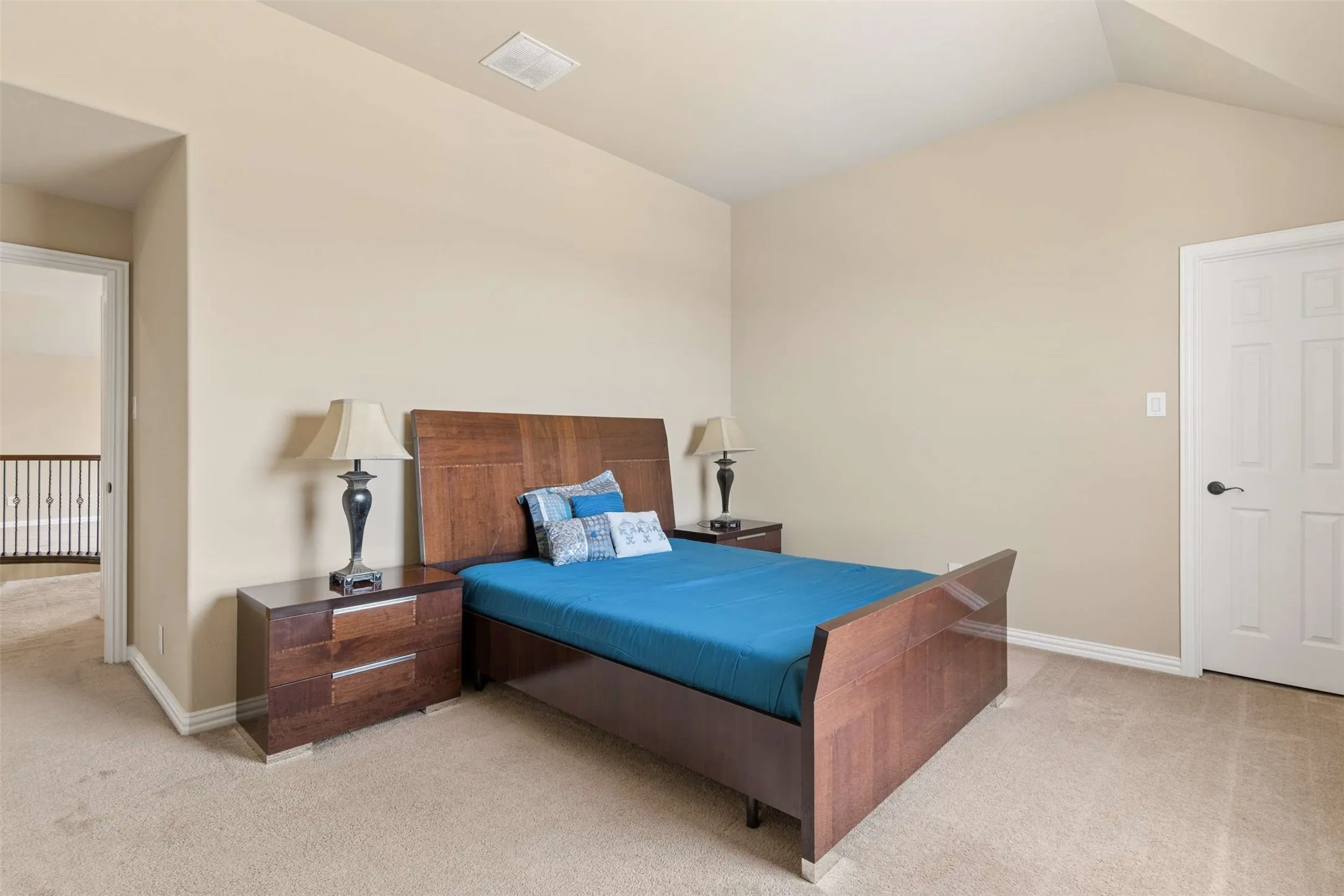Bedroom featuring light colored carpet and vaulted ceiling