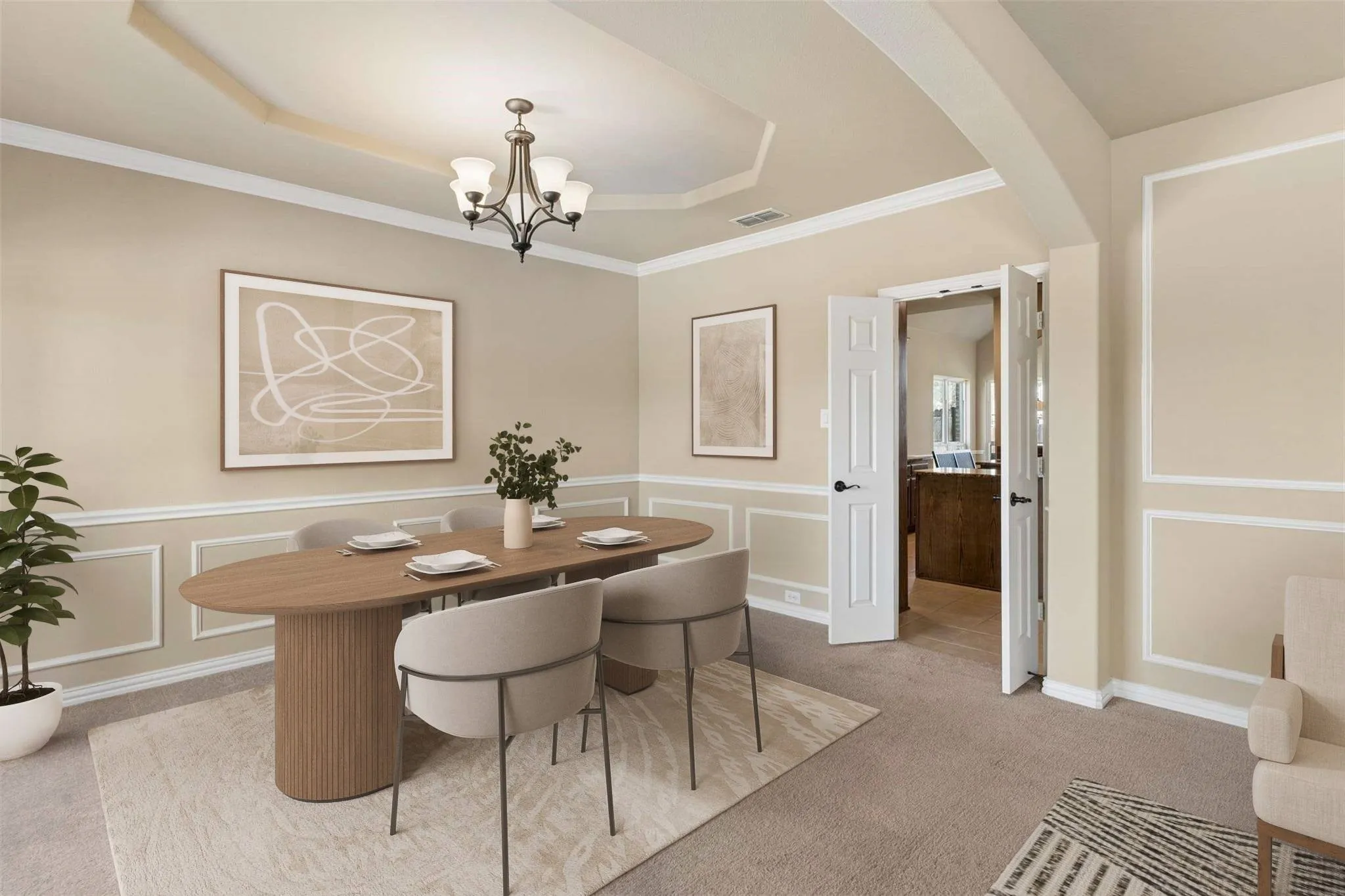 Formal dining area with tray ceiling, crown molding, and wainscoting