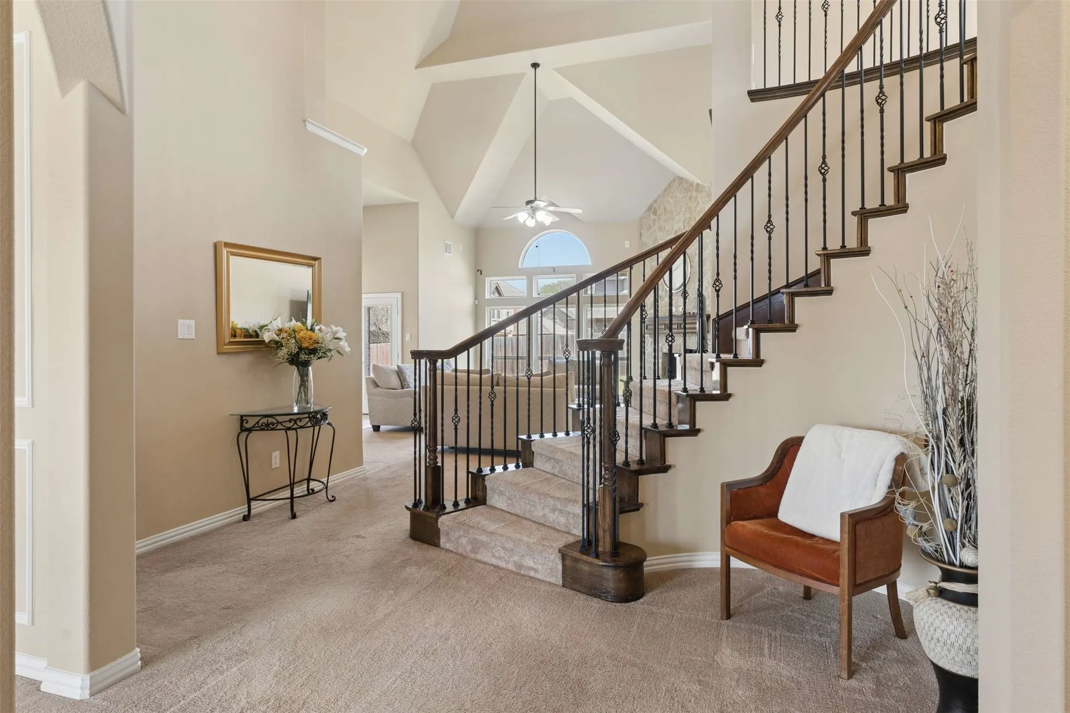 Stairway featuring a high ceiling, carpet, and ceiling fan