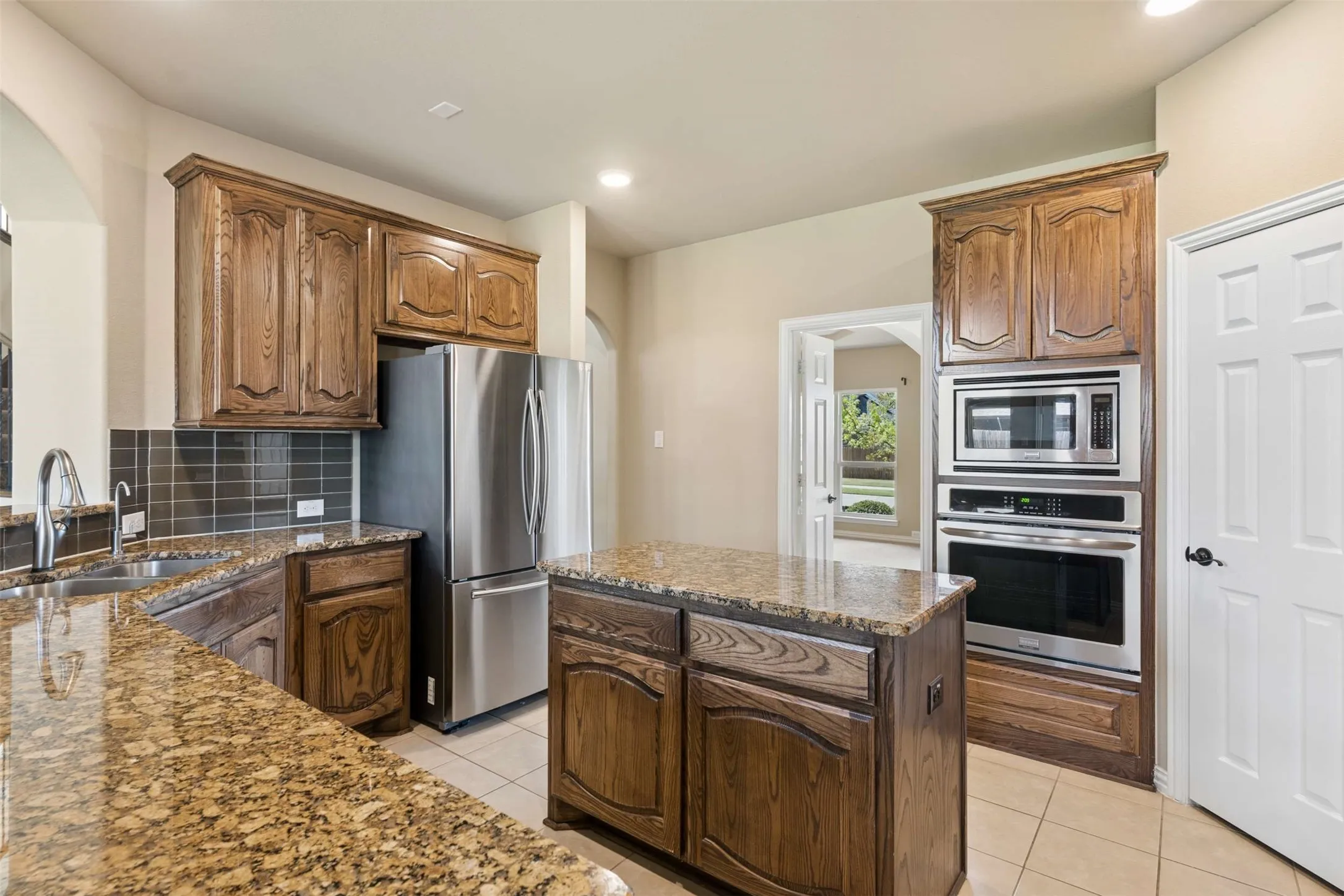 Kitchen featuring a center island, stainless steel appliances, dark stone countertops, light tile patterned floors, and recessed lighting