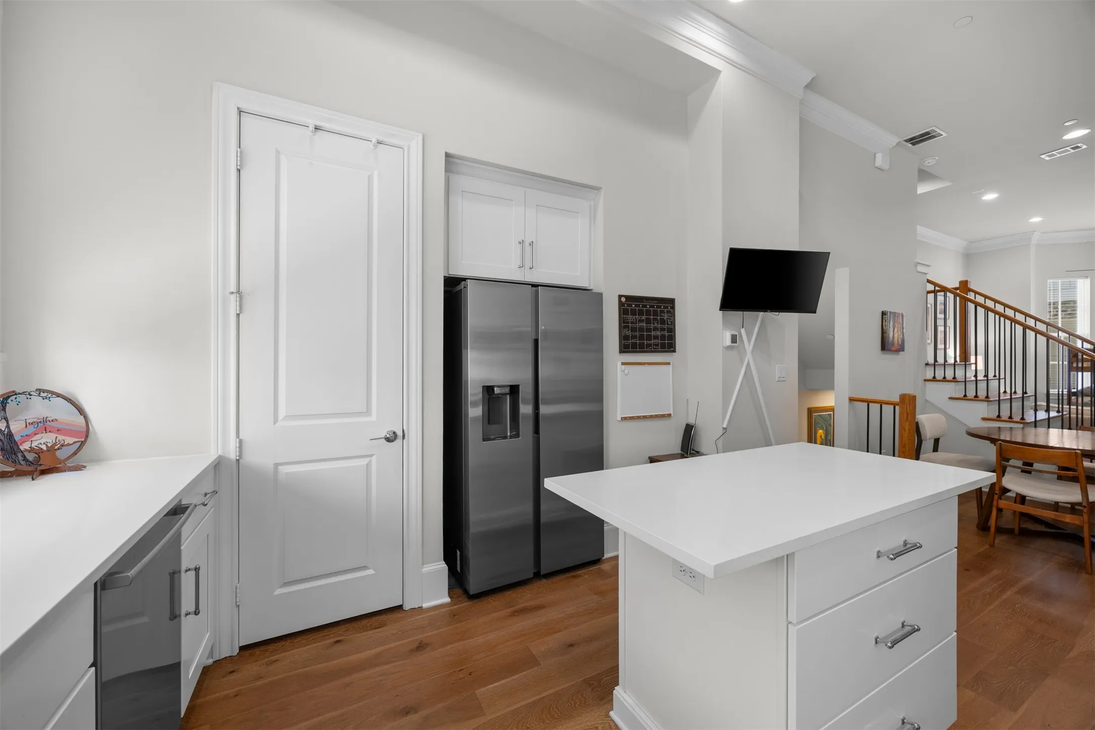 Kitchen featuring a center island with white cabinetry, white countertops, and wood-finish flooring