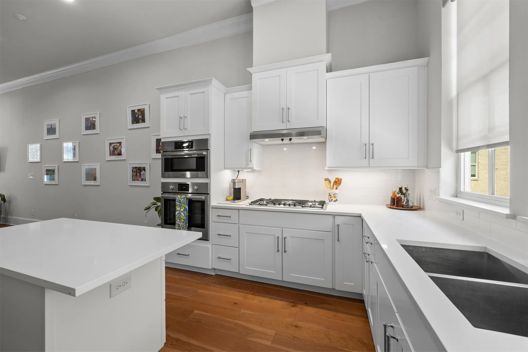 White shaker cabinetry paired with stainless steel appliances, white subway tile backsplash, and light-toned countertops