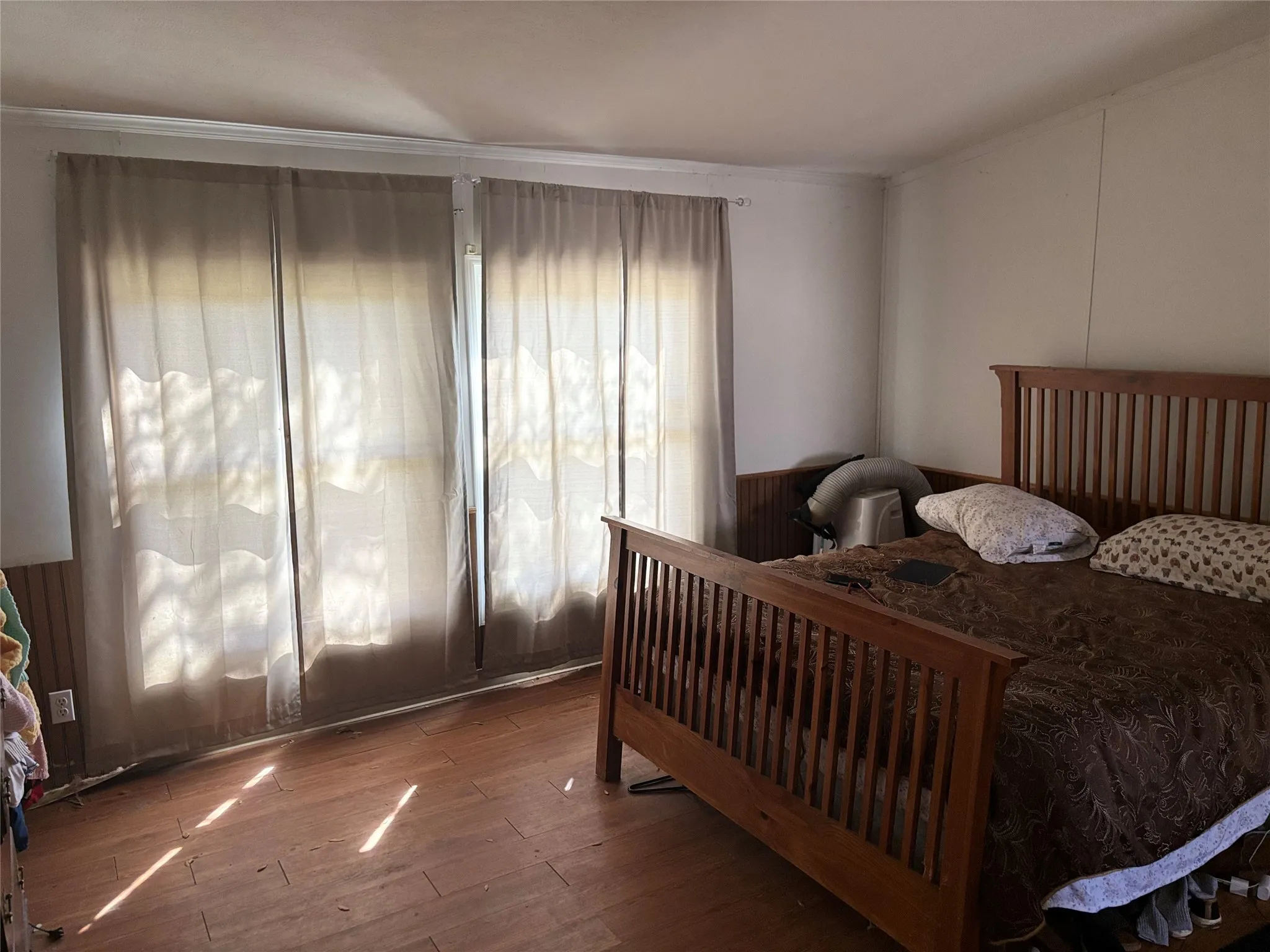 Bedroom featuring wood-type flooring and crown molding