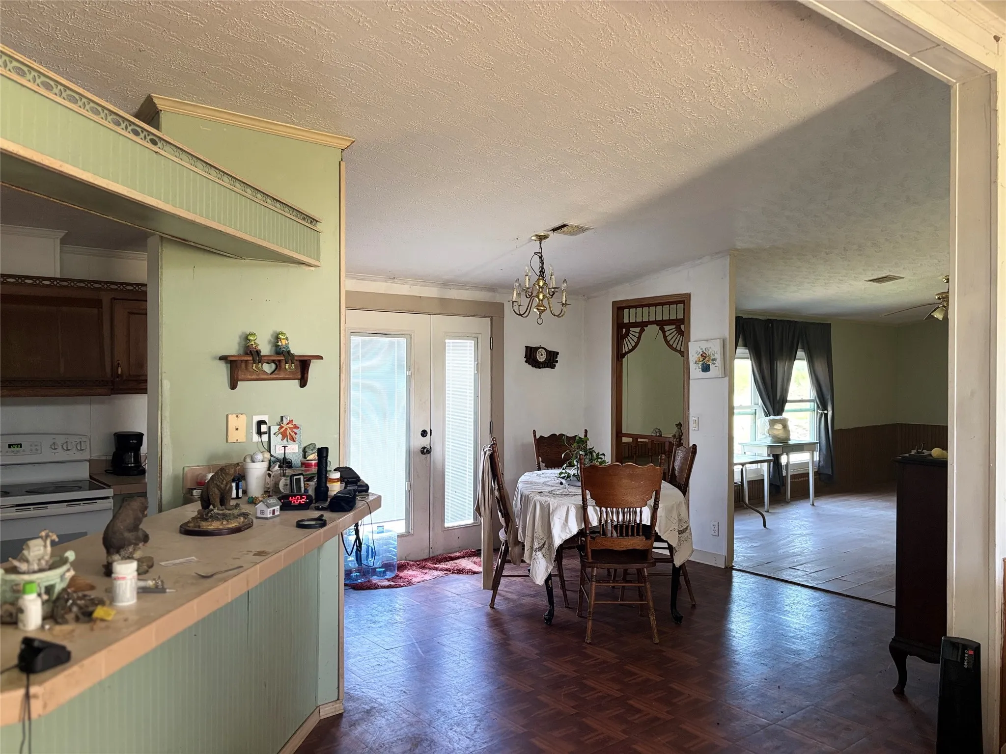 Dining room with parquet flooring, hanging lights, a wainscoted wall, and wooden walls