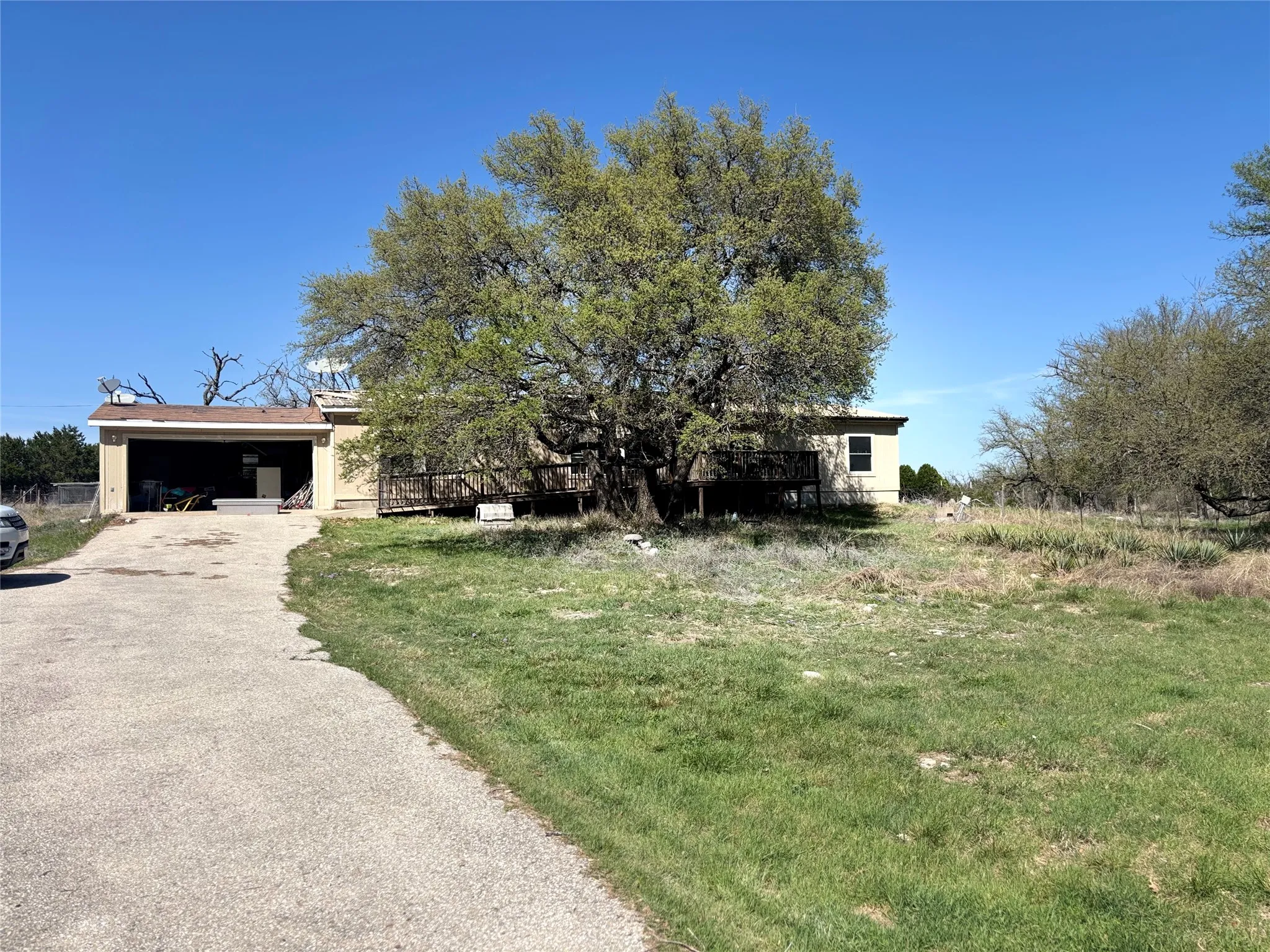 Obstructed view of property featuring driveway and a front lawn