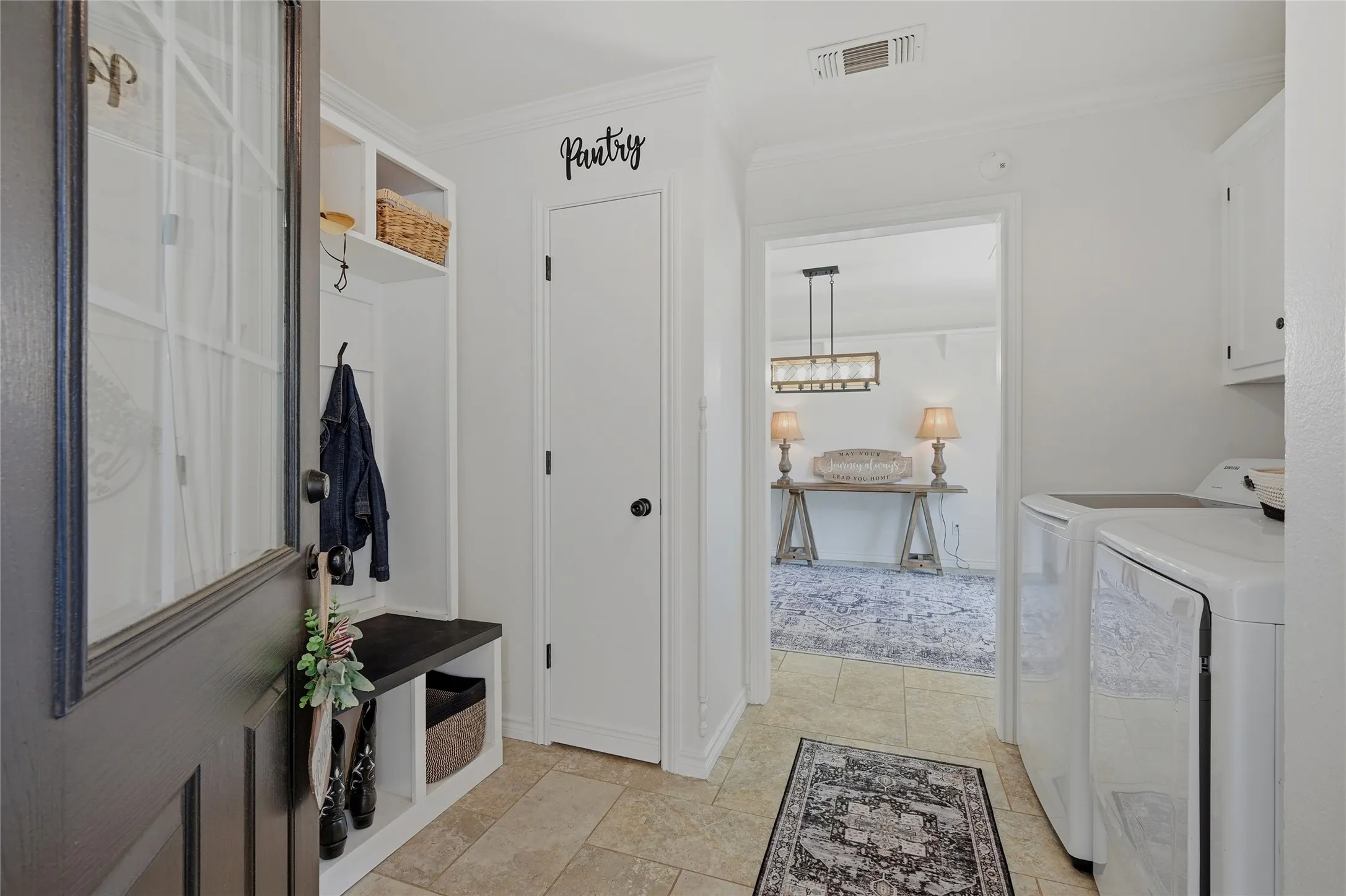 Mudroom featuring washing machine and clothes dryer and crown molding