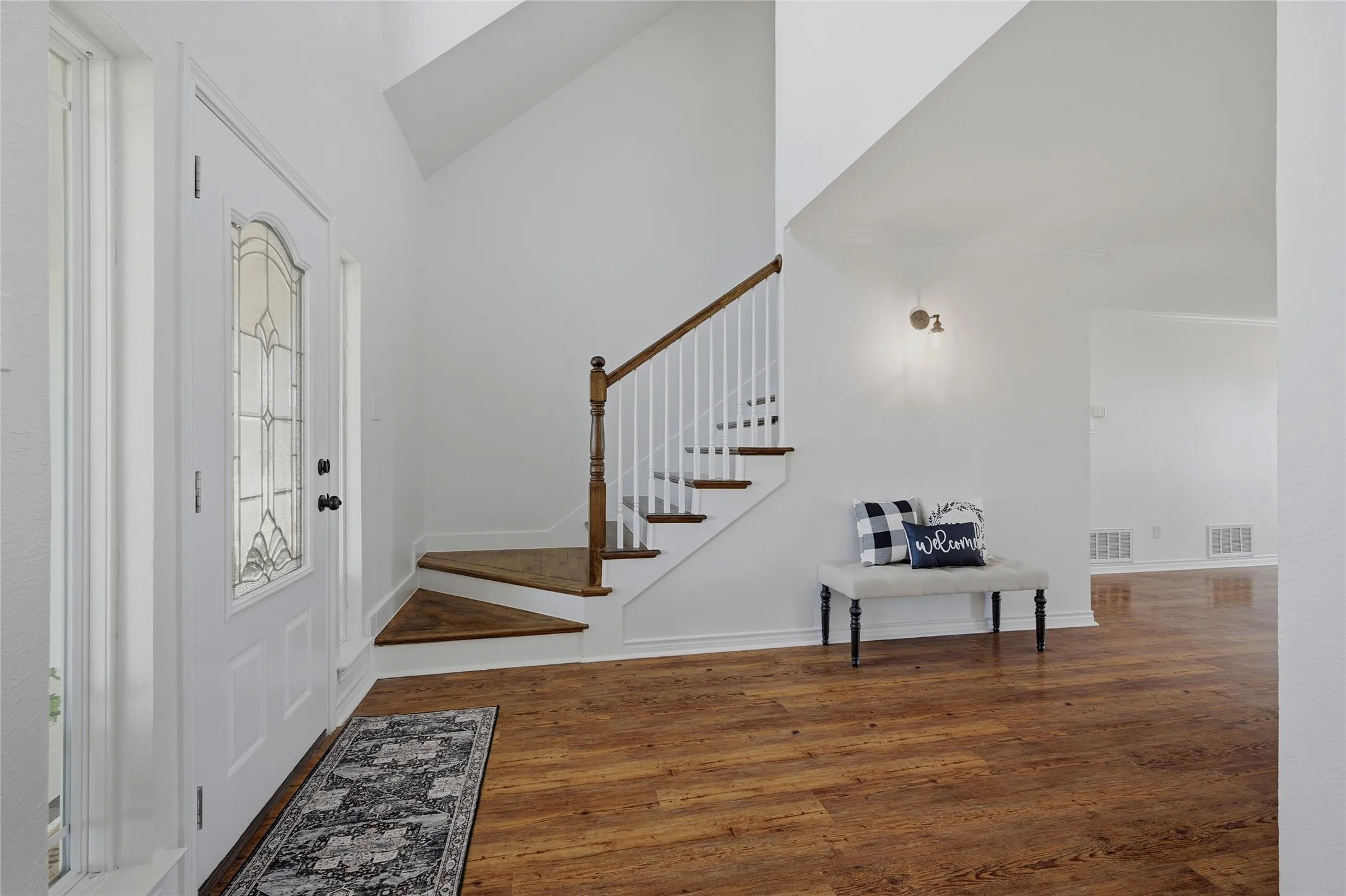 Foyer with dark wood finished floors and vaulted ceiling