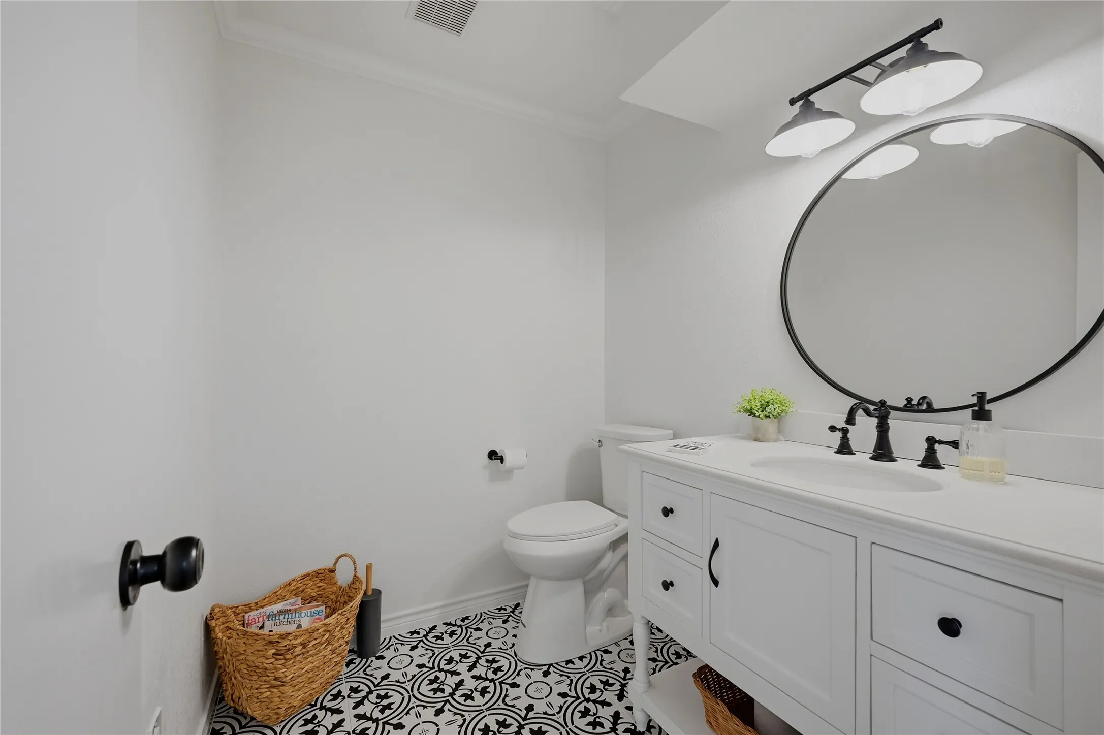 Bathroom featuring vanity, ornamental molding, and light tile patterned floors