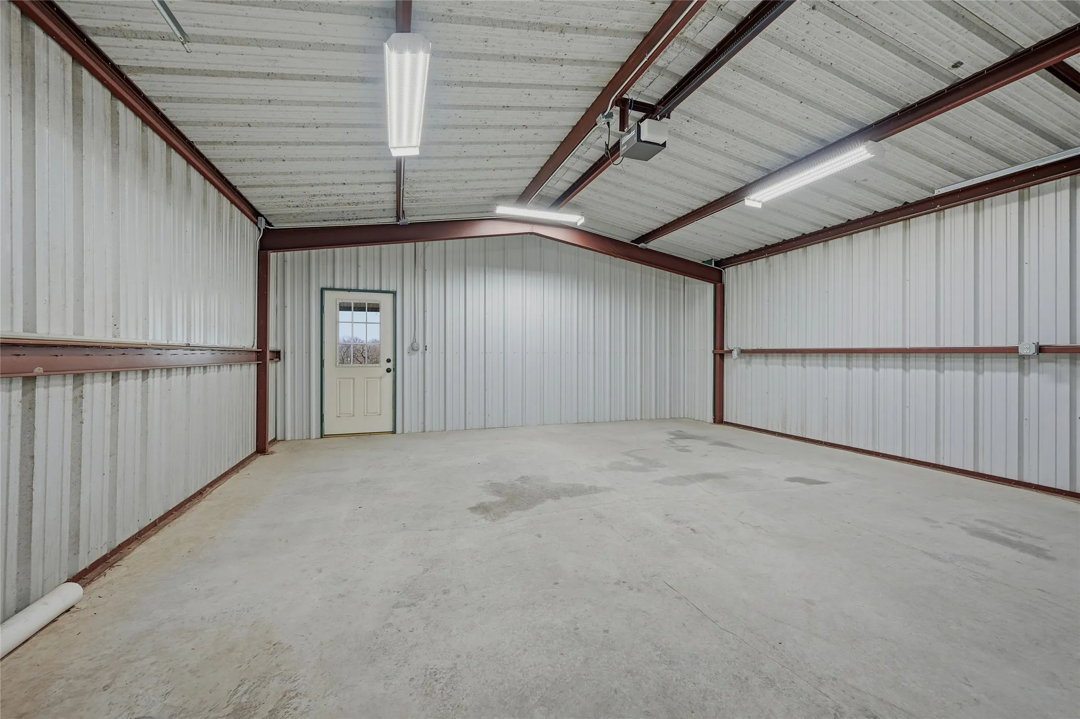 Garage featuring metal wall and a garage door opener