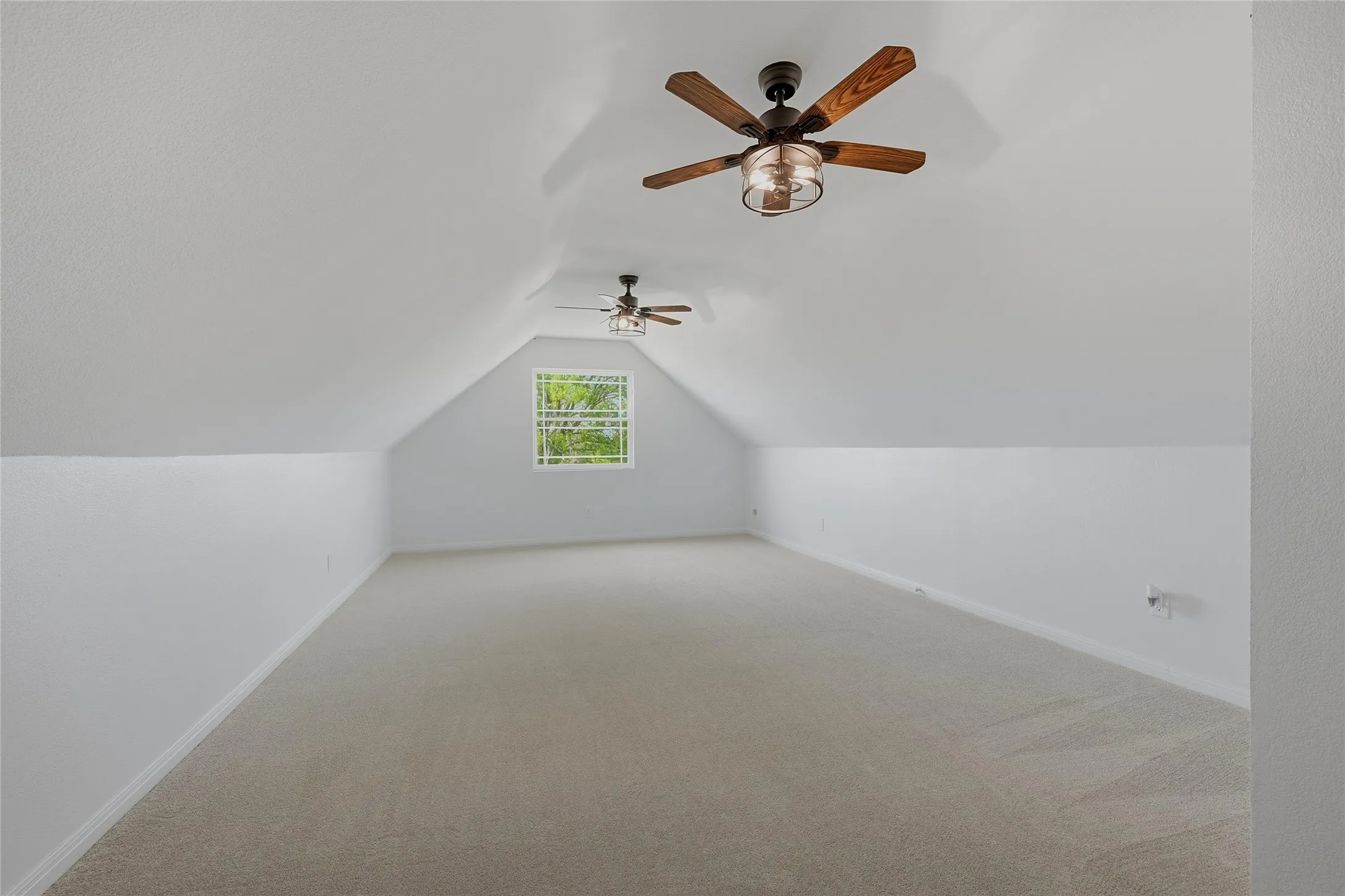 Bonus room featuring light colored carpet and ceiling fan