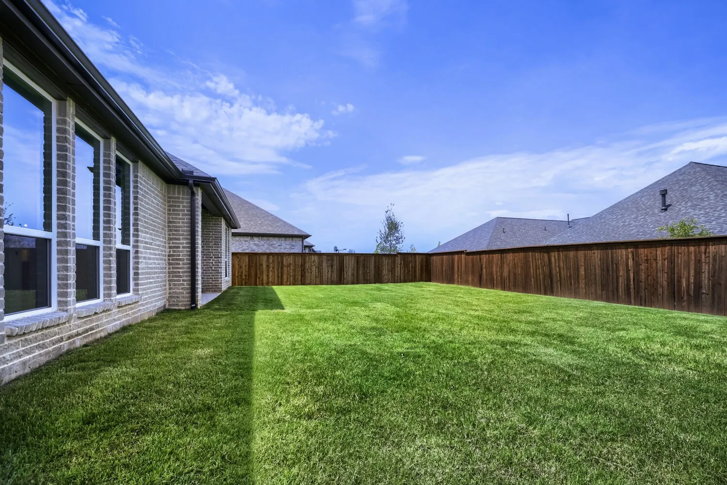 Spacious fenced backyard with a manicured lawn