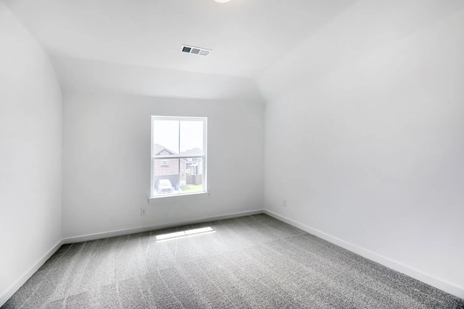 Room featuring neutral white walls, gray patterned carpeting, a single window, white trim, and a ceiling light fixture