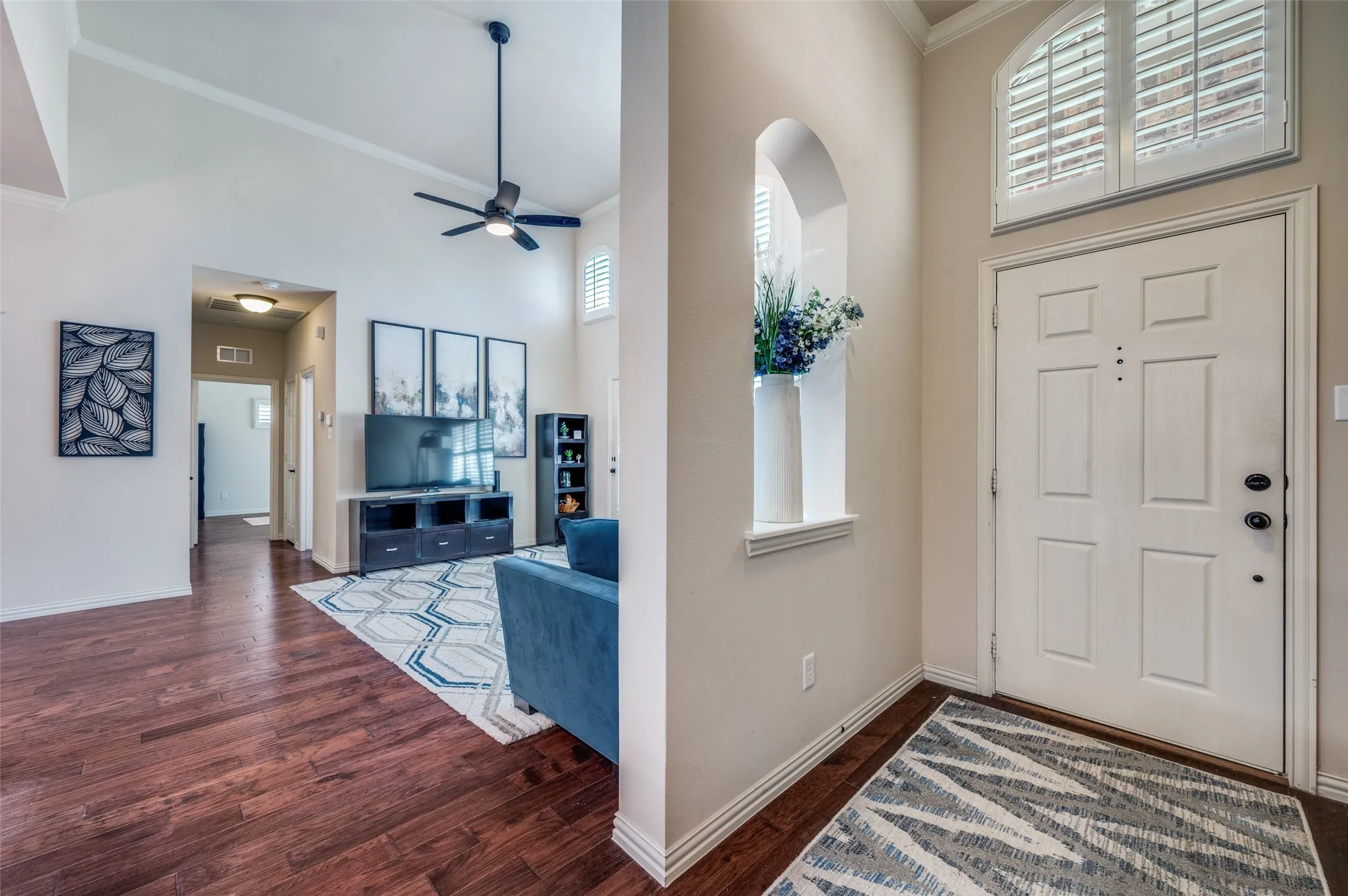 Light, bright entry with primary suite to the left and living, kitchen to the right.