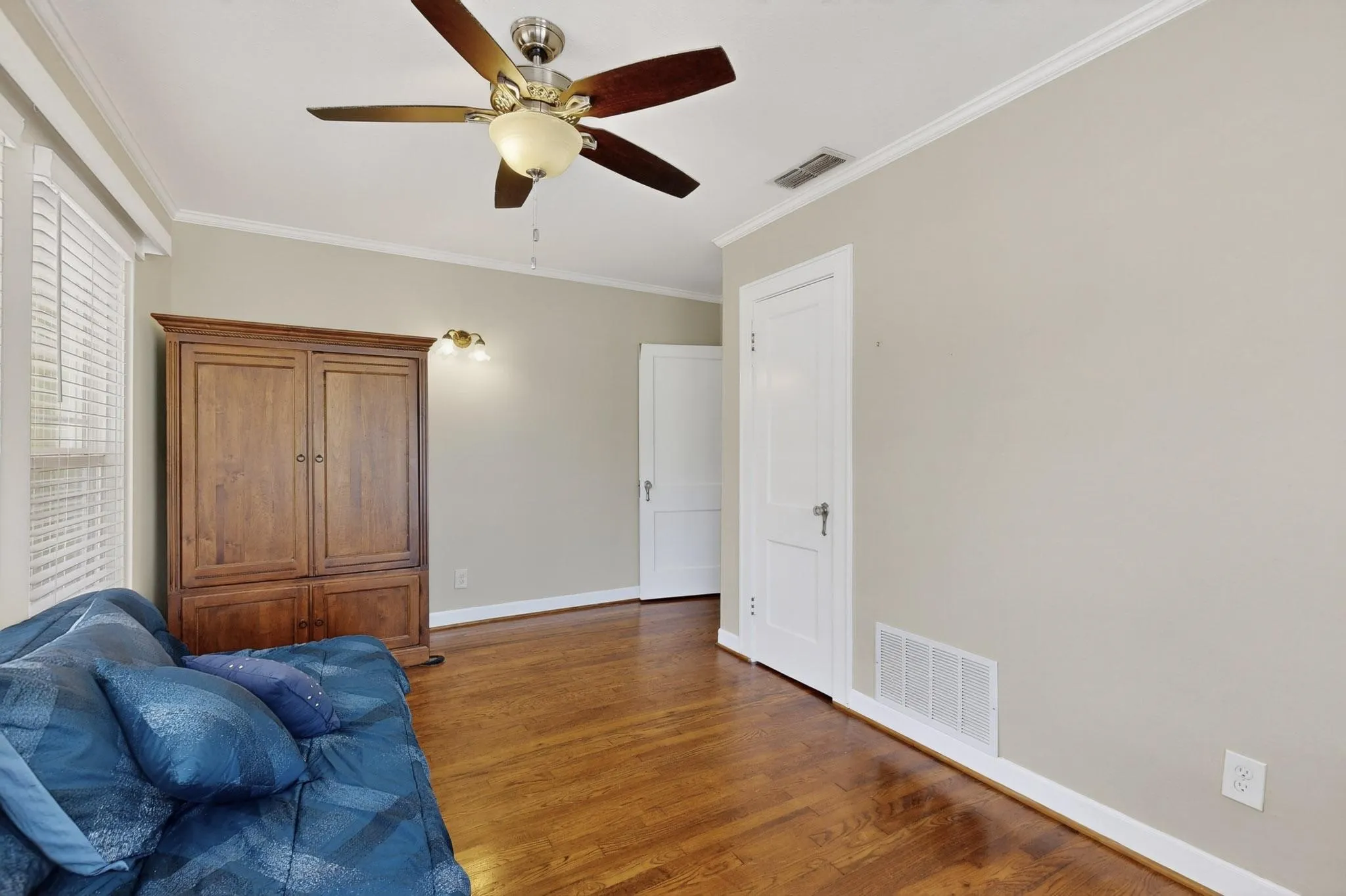 Sitting room featuring crown molding, wood finished floors, and ceiling fan