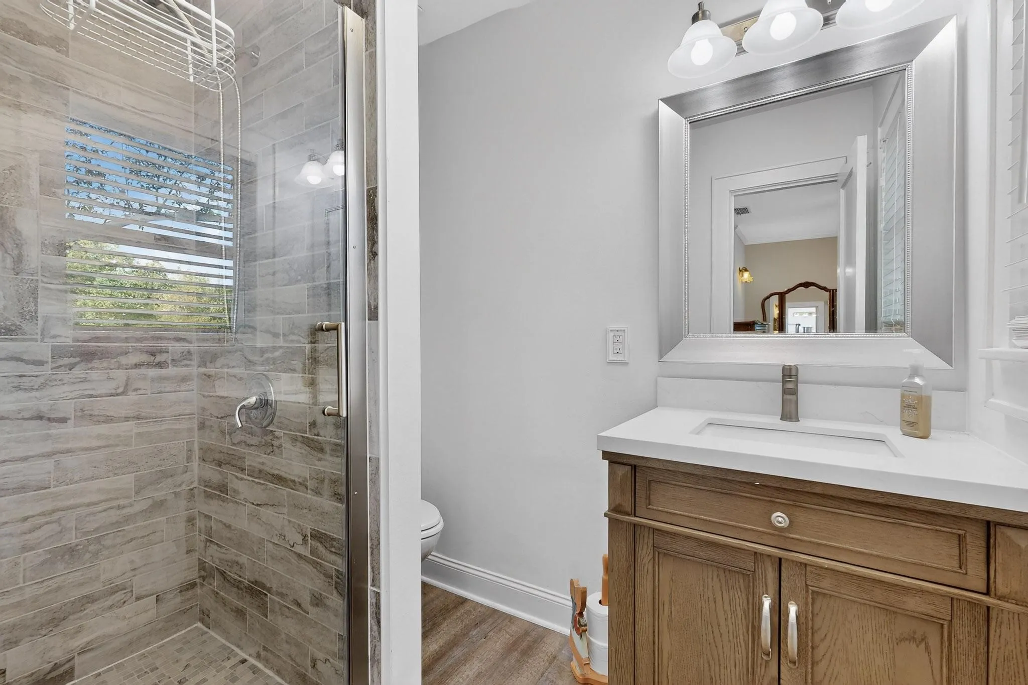 Bathroom with vanity, a shower stall, and light wood-style floors