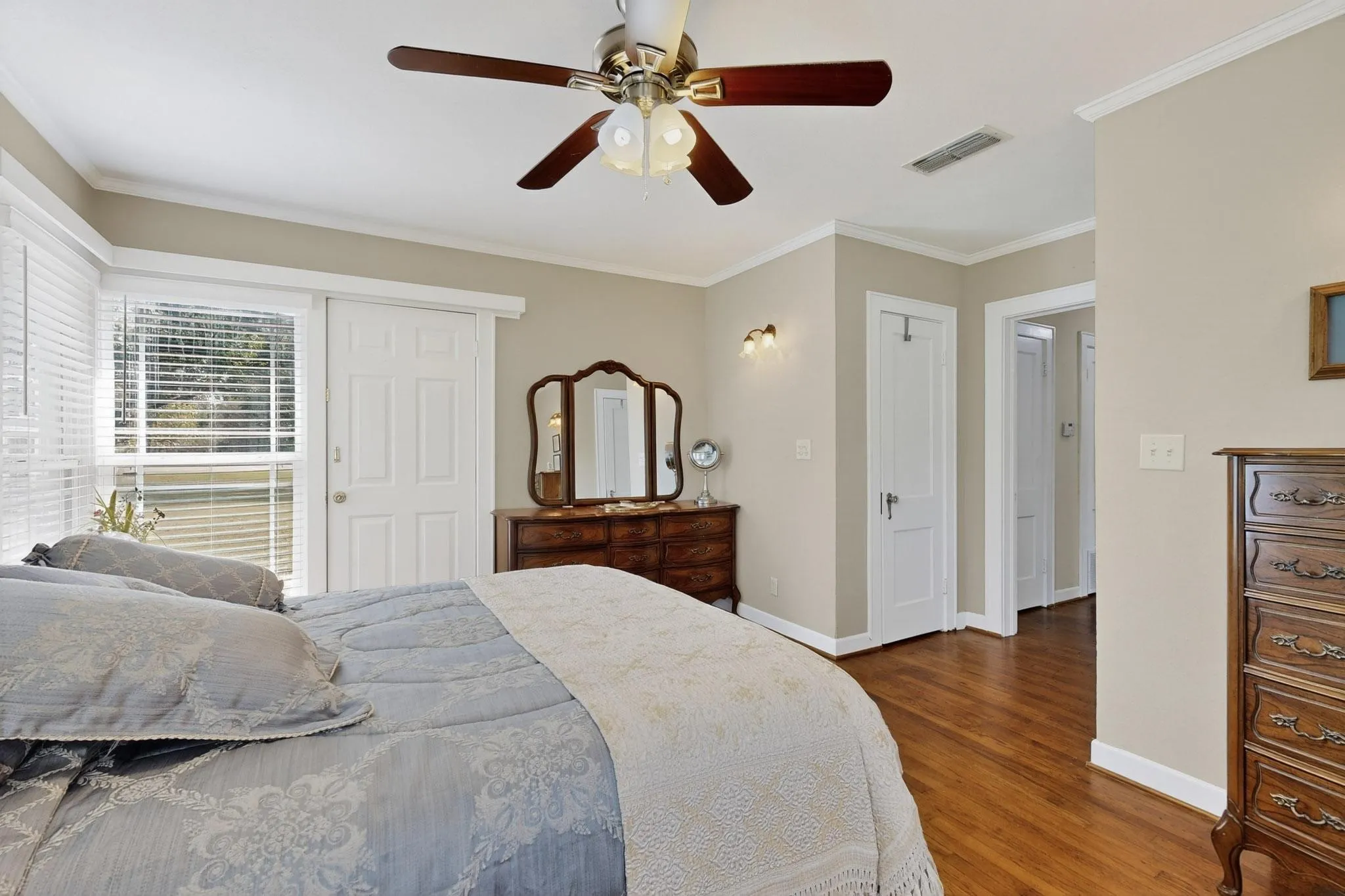 Bedroom with ornamental molding, wood finished floors, and ceiling fan