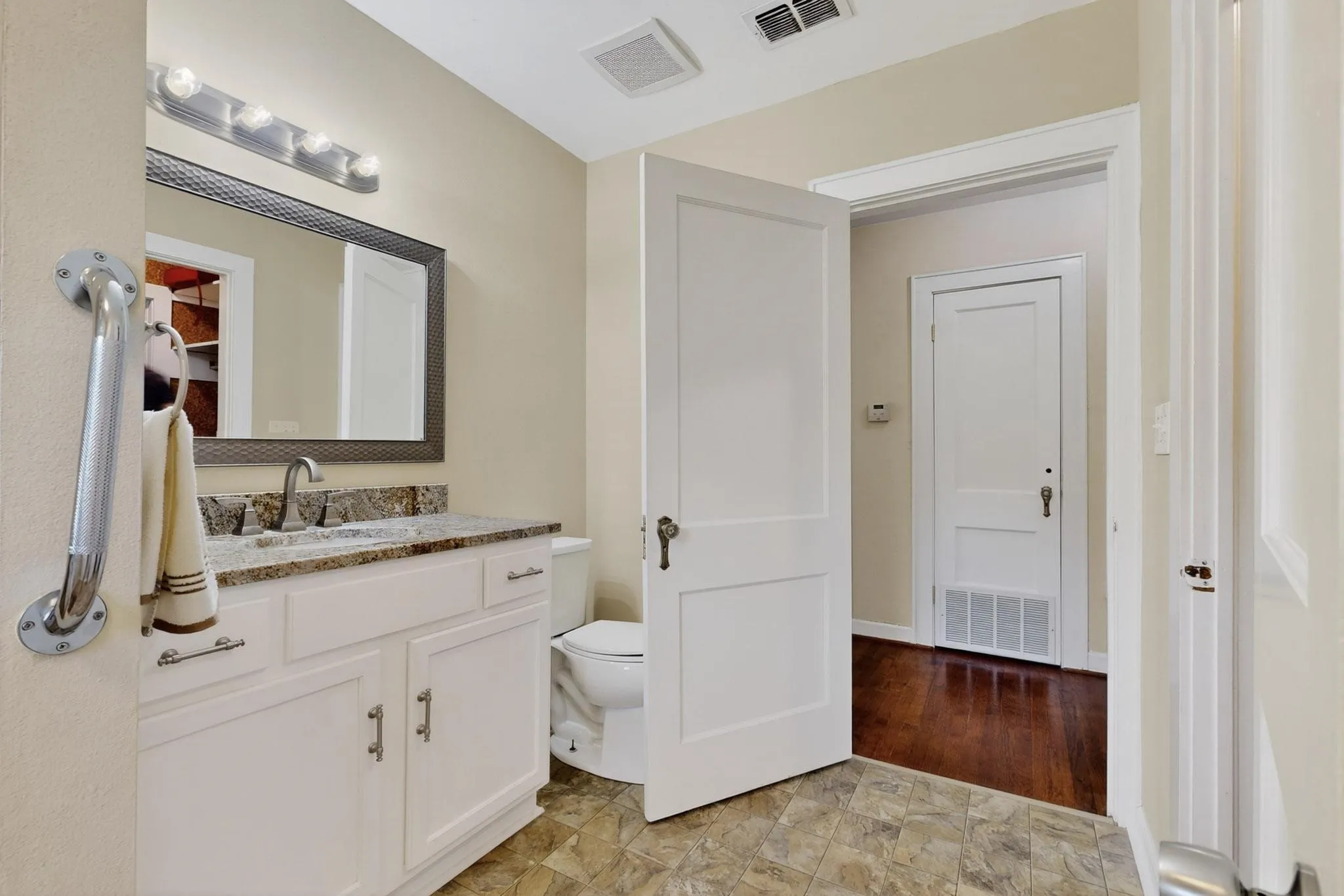 Half bathroom with vanity and light stone finish floors