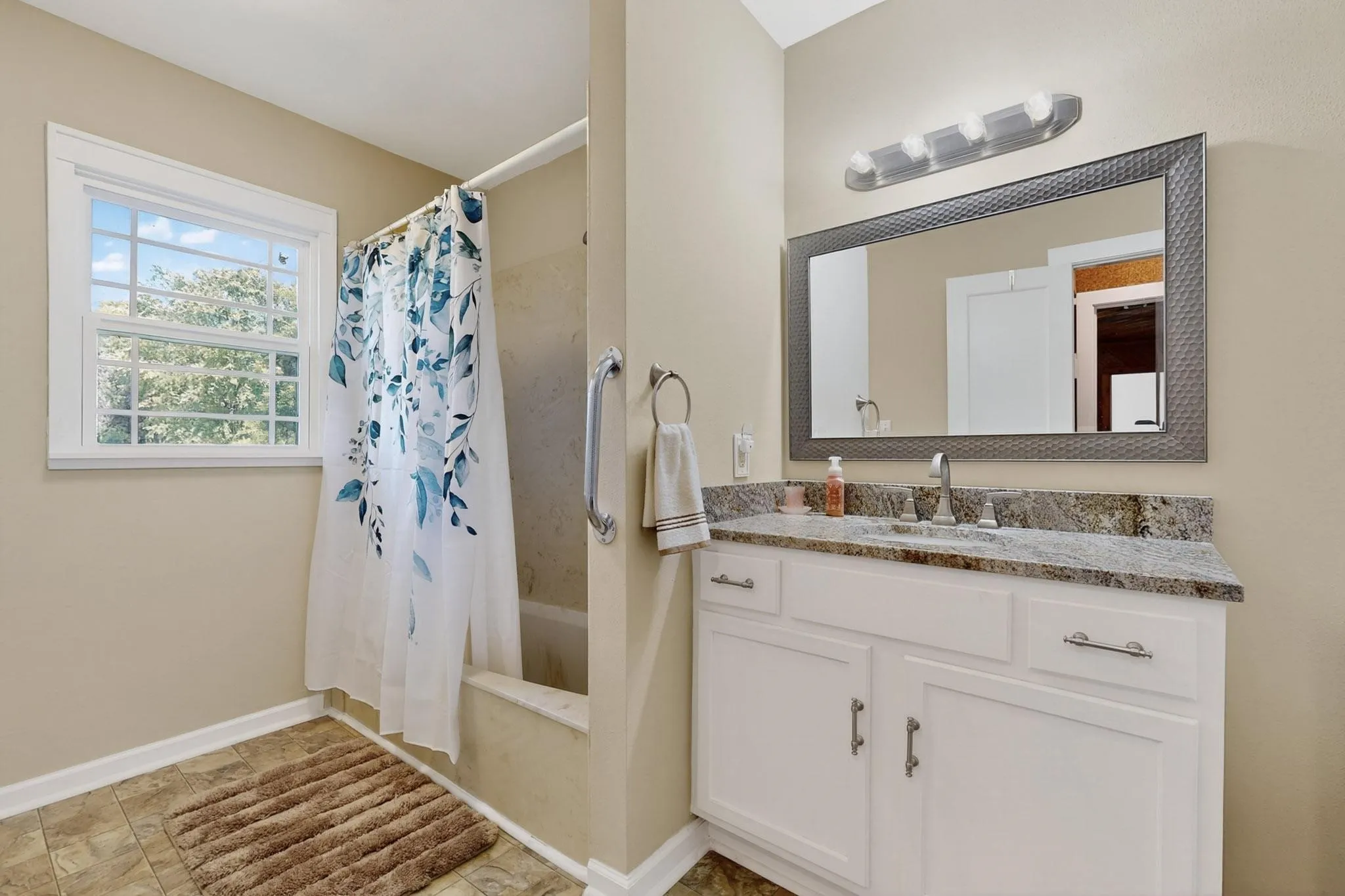 Bathroom with shower / bath combo with shower curtain and vanity
