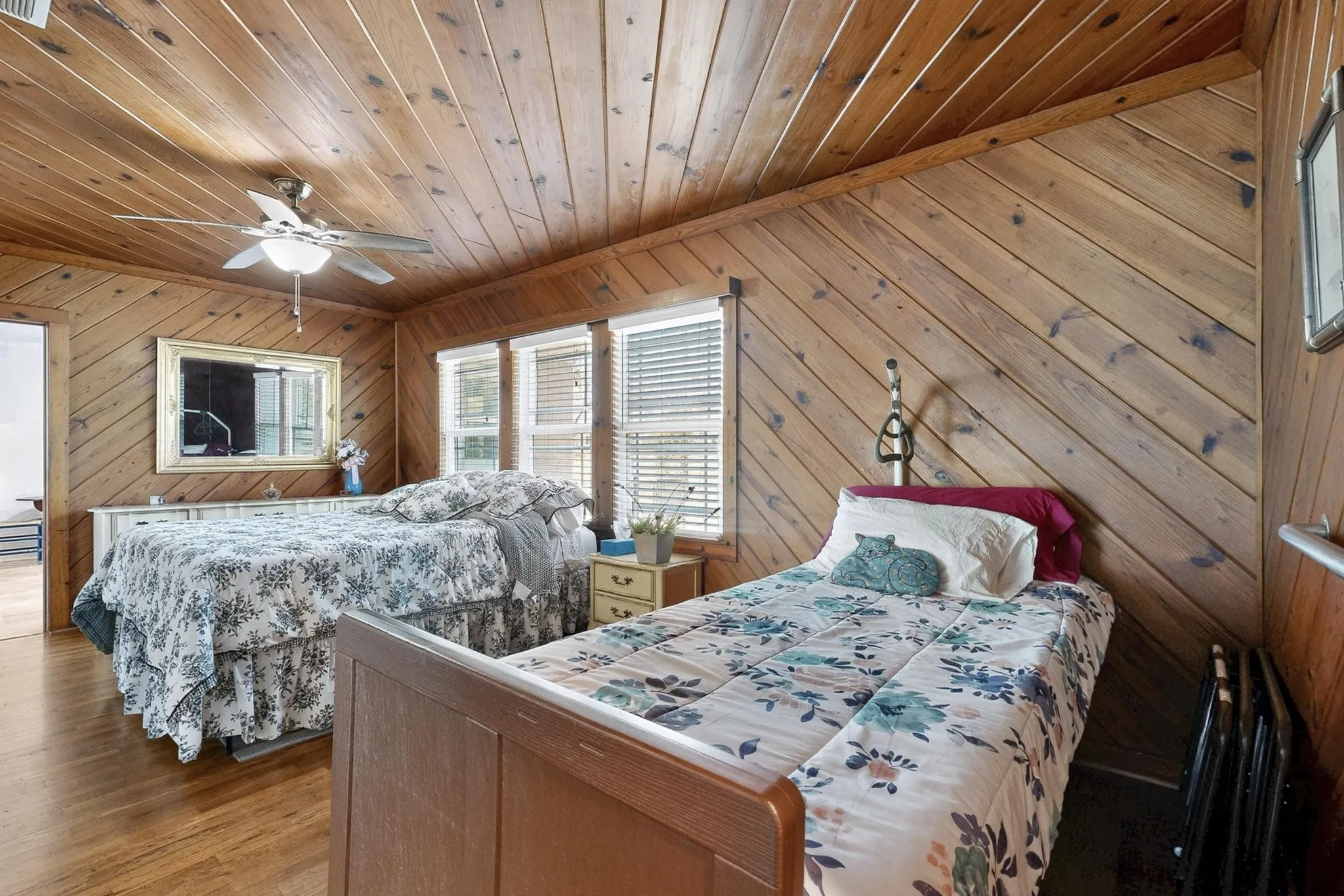 Bedroom featuring wood walls, ceiling fan, wood finished floors, and wooden ceiling